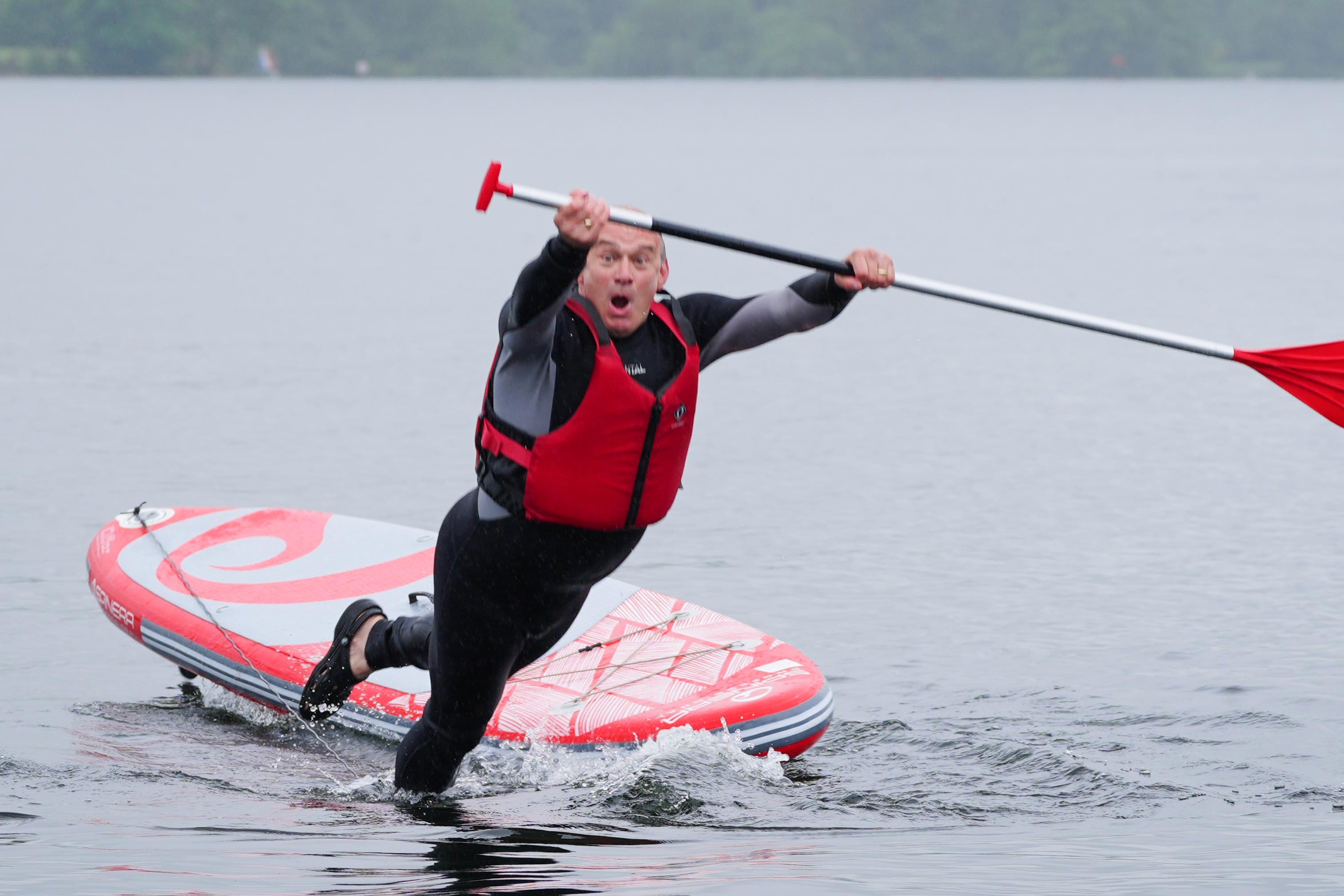 Liberal Democrat leader Sir Ed Davey falls into the water while paddleboarding on Lake Windermere (Peter Byrne/PA)