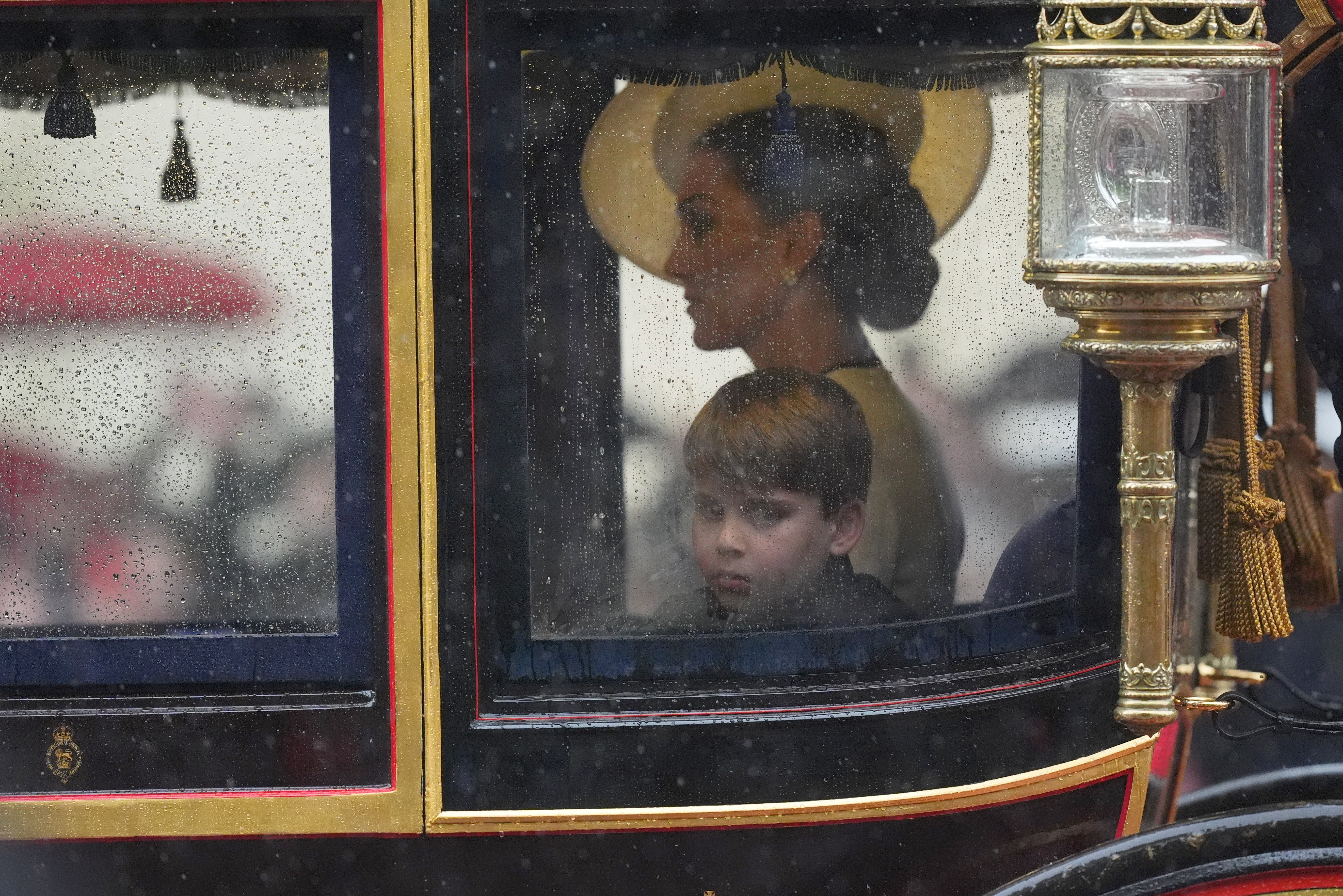 The Princess of Wales and Prince Louis safely in the carriage as they proceed along the rainsoaked Mall