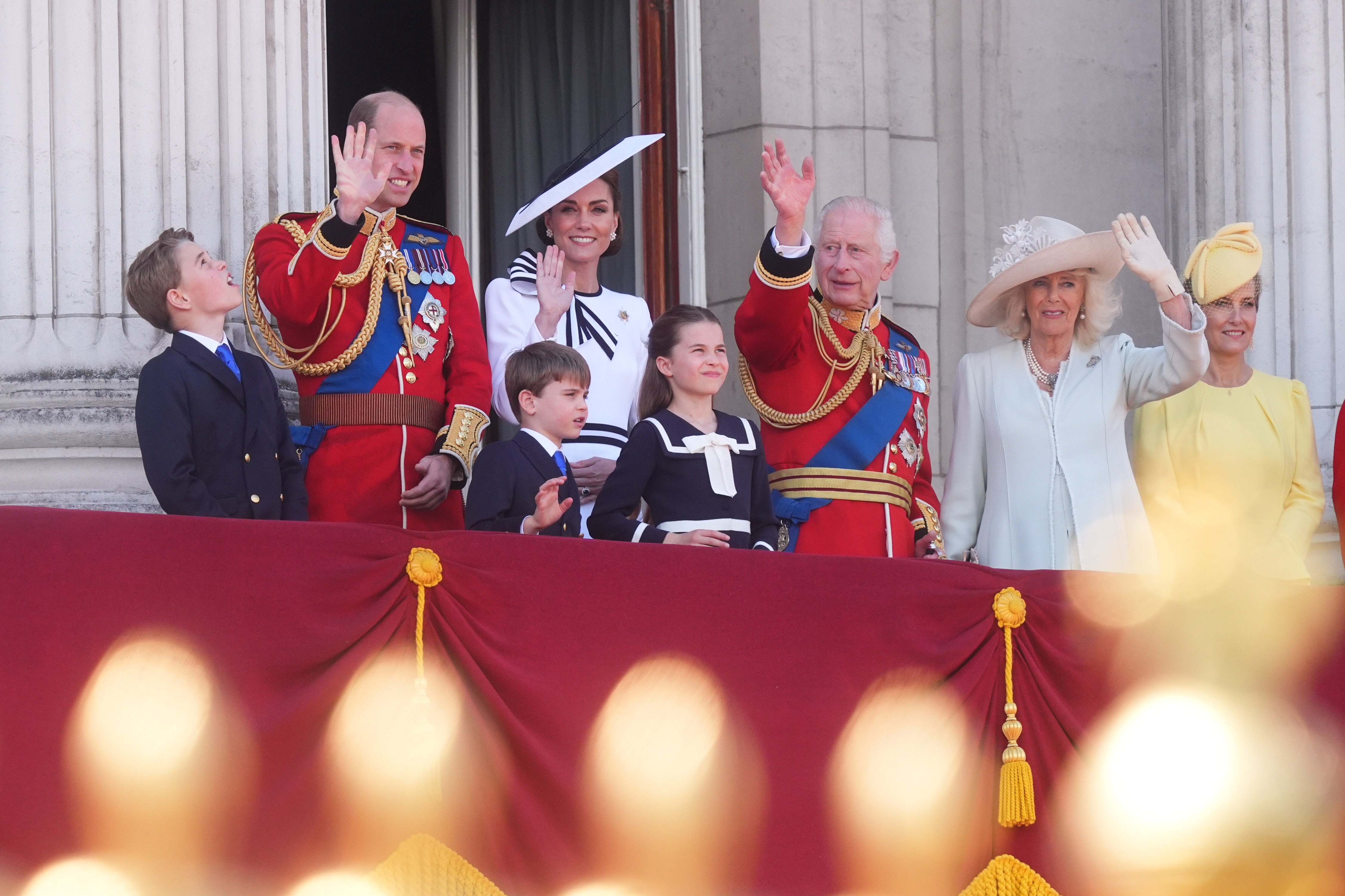 The King, the Prince and Princess of Wales and their children wave from the balcony