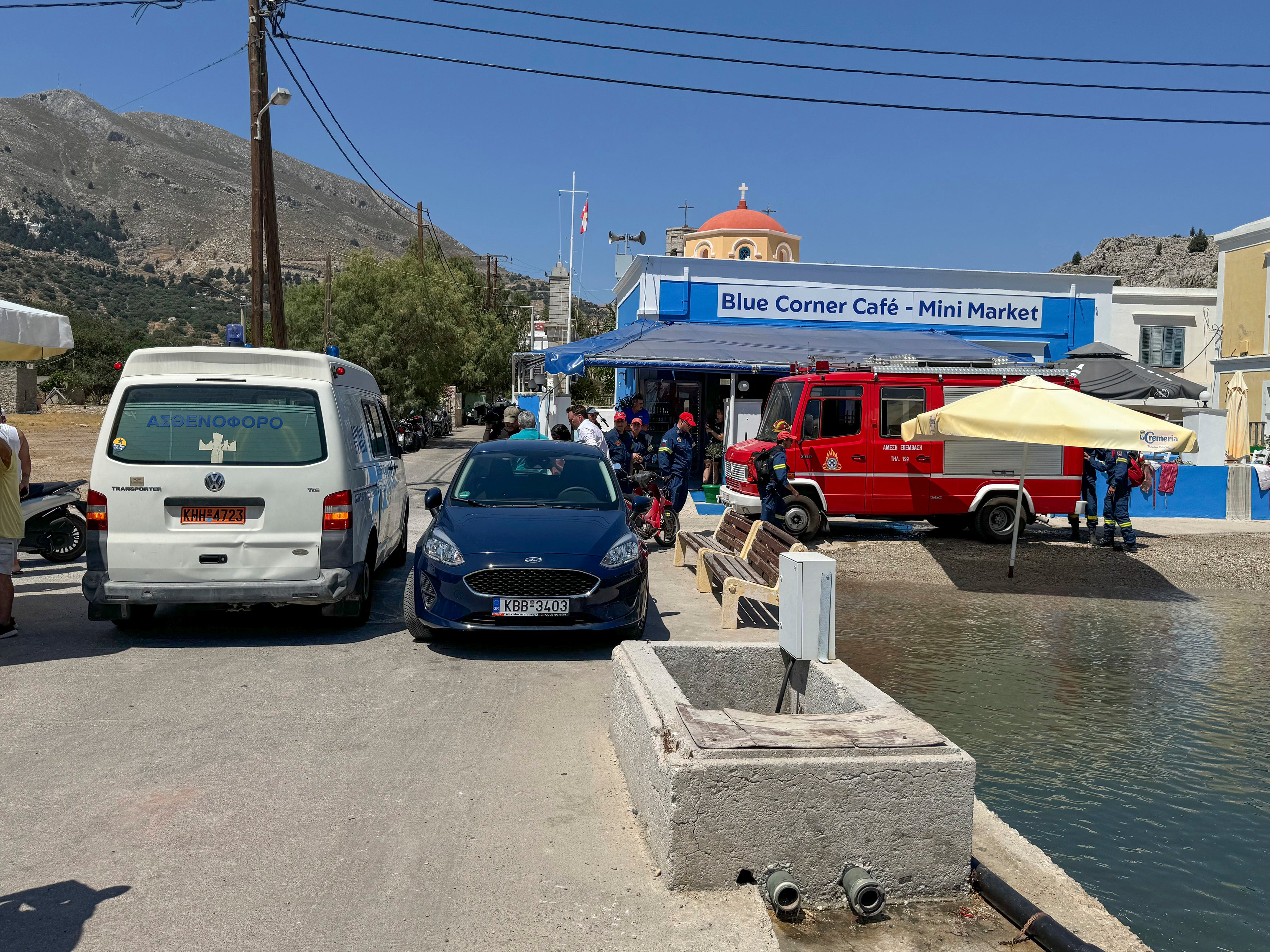Blick auf einen Krankenwagen und ein Feuerwehrauto am Meeresufer auf der Insel Symi, Griechenland