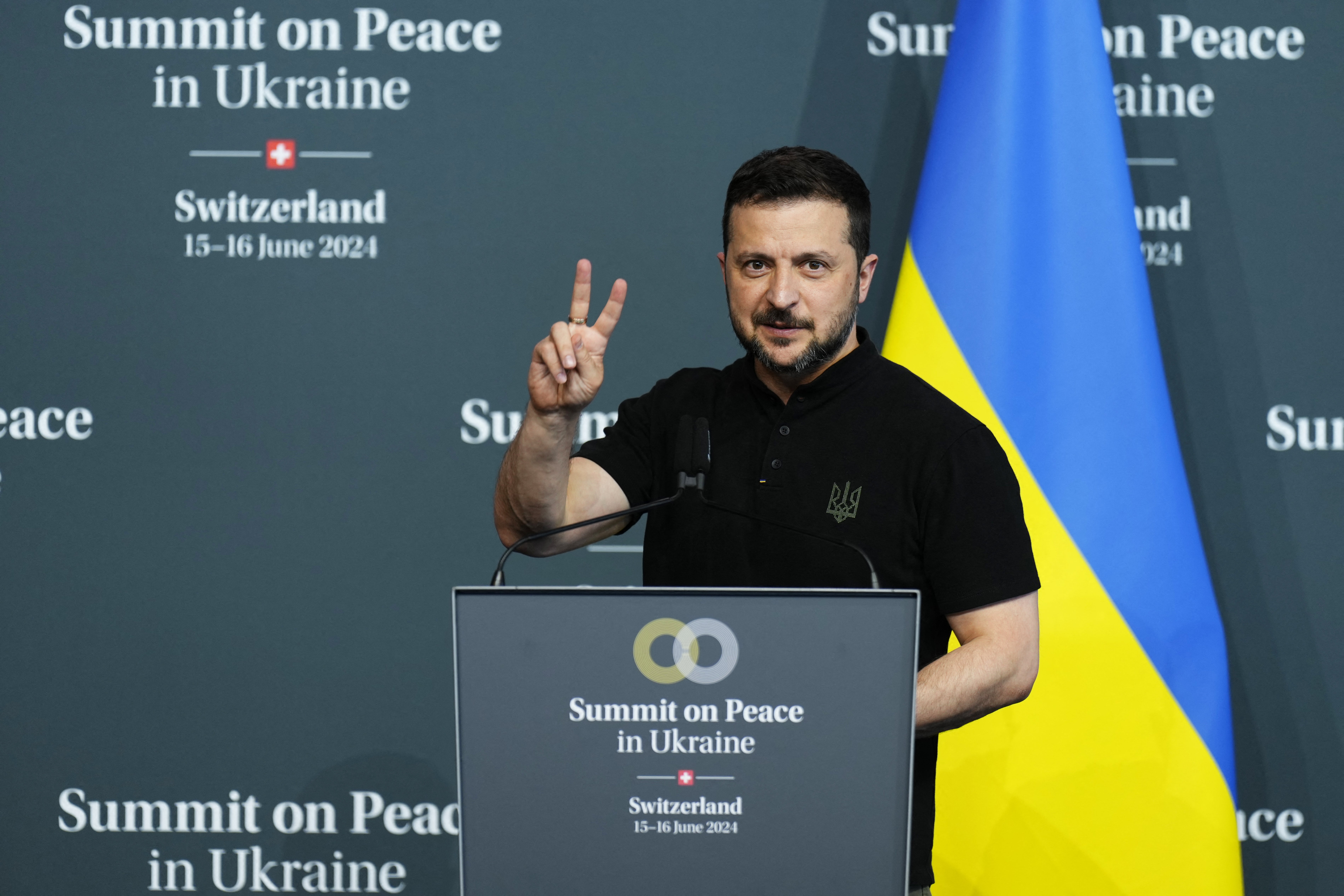 Президент Украины Владимир Зеленский показывает знак V, выступая на заключительной пресс-конференции украинского саммита за мир в Украине на роскошном курорте Бургеншток недалеко от Люцерна, Швейцария.