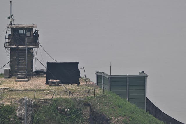 <p>A South Korean soldier stands guard near a military facility (R, green box) where loudspeakers dismantled in 2018 used to be, near the demilitarized zone separating the two Koreas</p>
