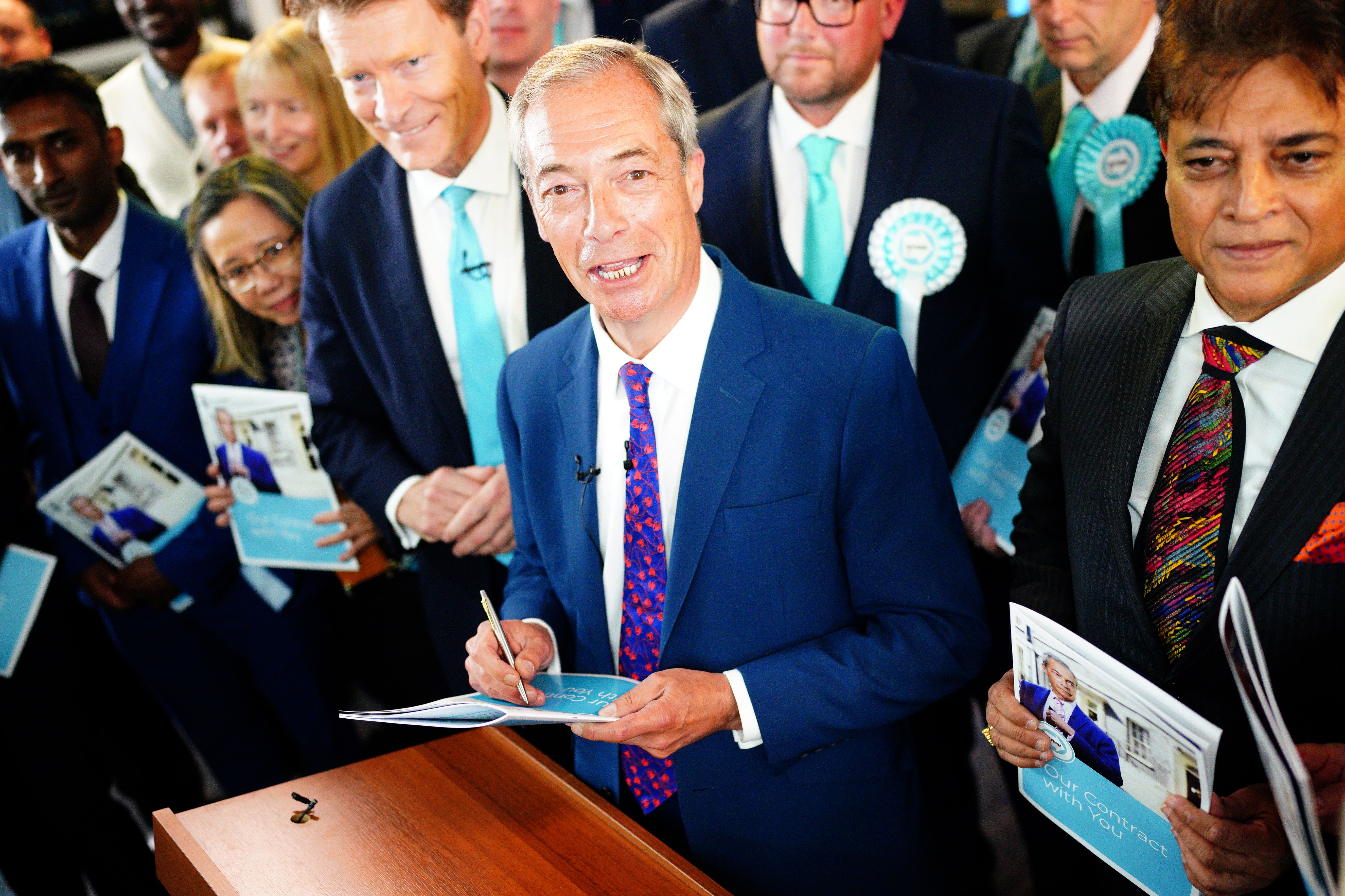 Nigel Farage signs a copy of his party’s manifesto following its launch in Merthyr Tydfil