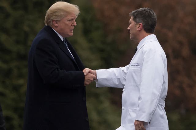 <p>Donald Trump (left) shakes hands with Ronny Jackson (right) in 2018. The former president forgot Jackson’s name seconds after challenging Joe Biden to a cognitive test</p>