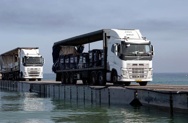 <p>This image provided by the U.S. Army shows trucks loaded with humanitarian aid from the United Arab Emirates and the United States Agency for International Development cross the Trident Pier before arriving on the beach on the Gaza Strip, May 17, 2024</p>