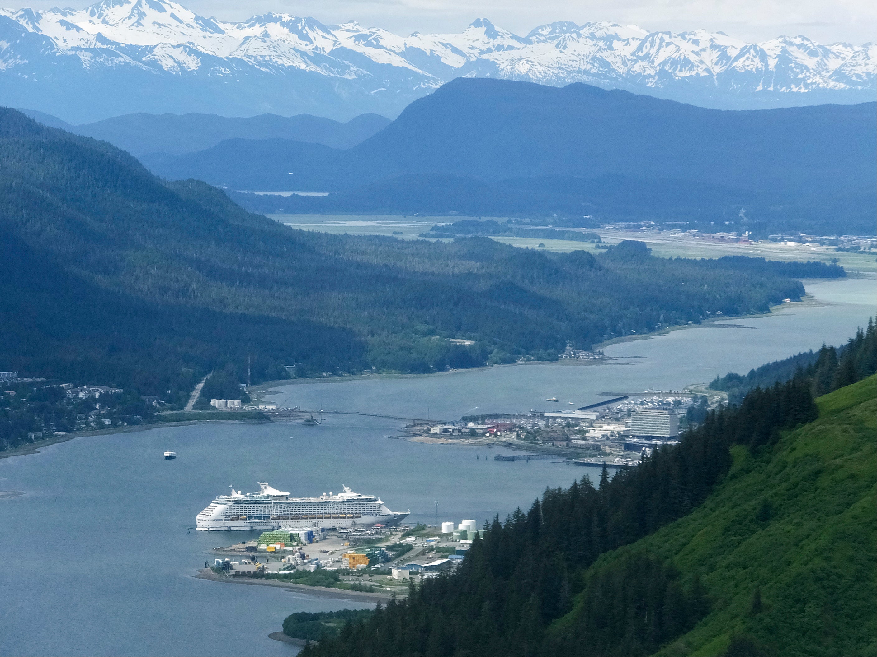 A cruise ship dwarfed by nature as it rests beside the Juneau docks in June 2017