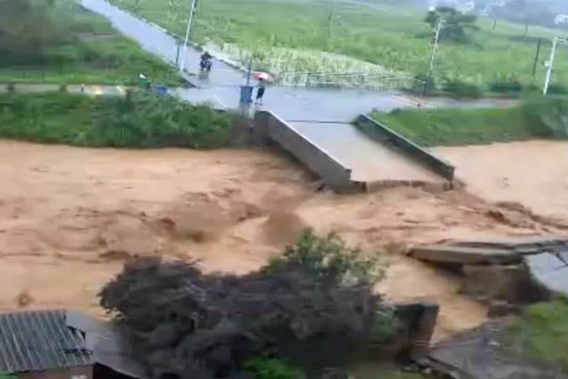 <p>A person stands next to a collapsed bridge following heavy rainfall and flooding in Dongshi Town, Guangdong Province, China</p>