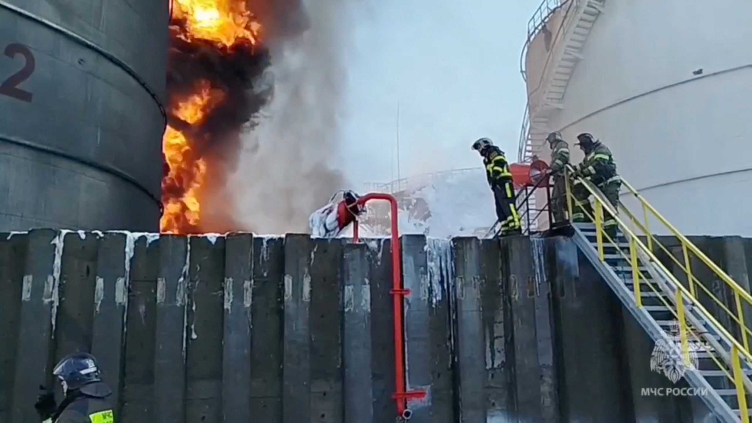 Members of the Russian Emergencies Ministry work to put out a fire at an oil storage tank after a suspected drone attack in the city of Azov in the southern Rostov region.