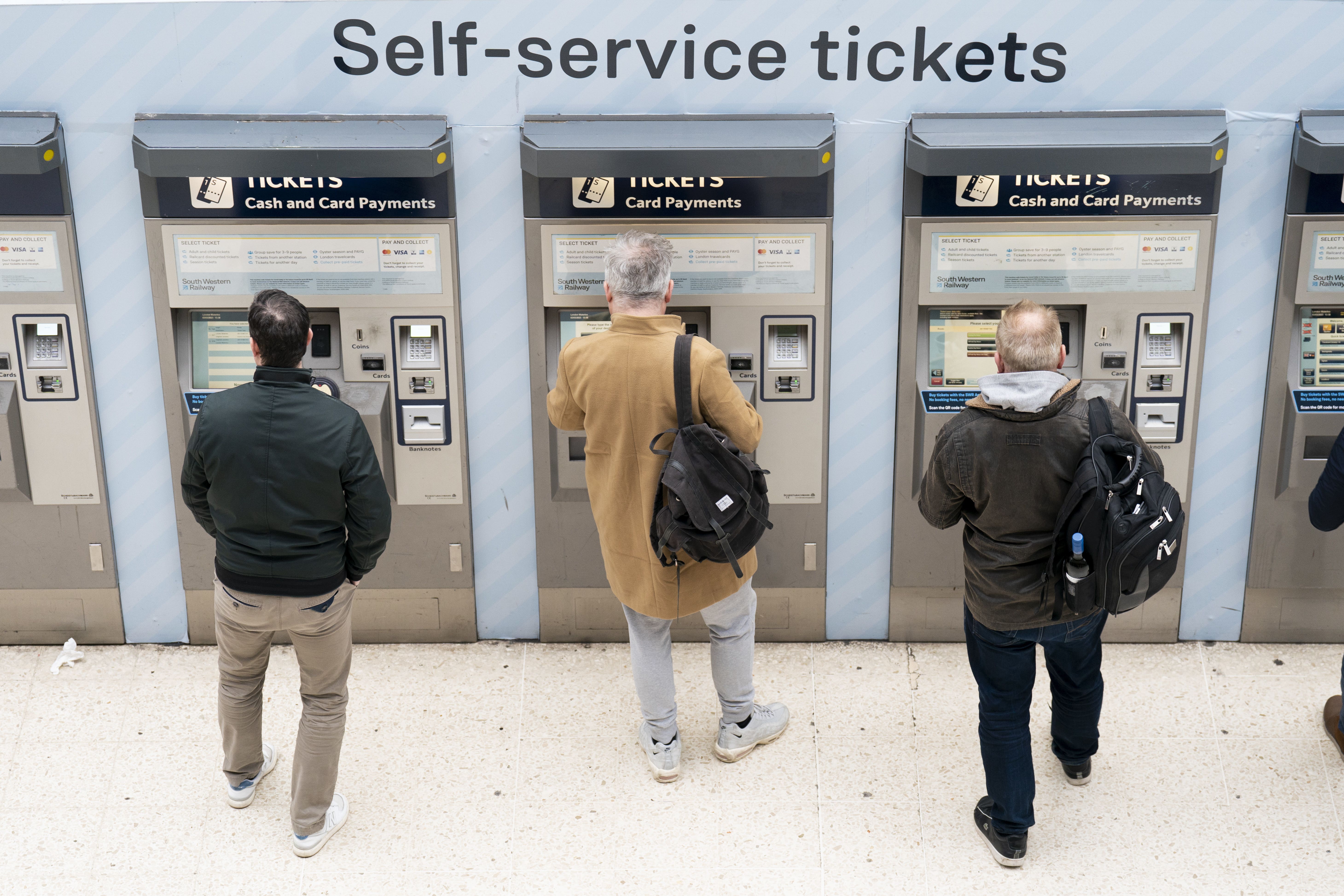 Passengers using a ticket machine at London Waterloo station