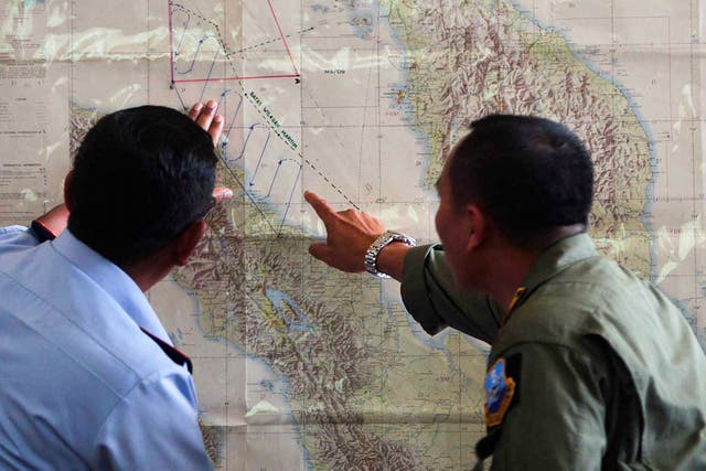 <p>Indonesian Air Force officials plot a search operation for Malaysian Airlines flight MH370 in 2014</p>