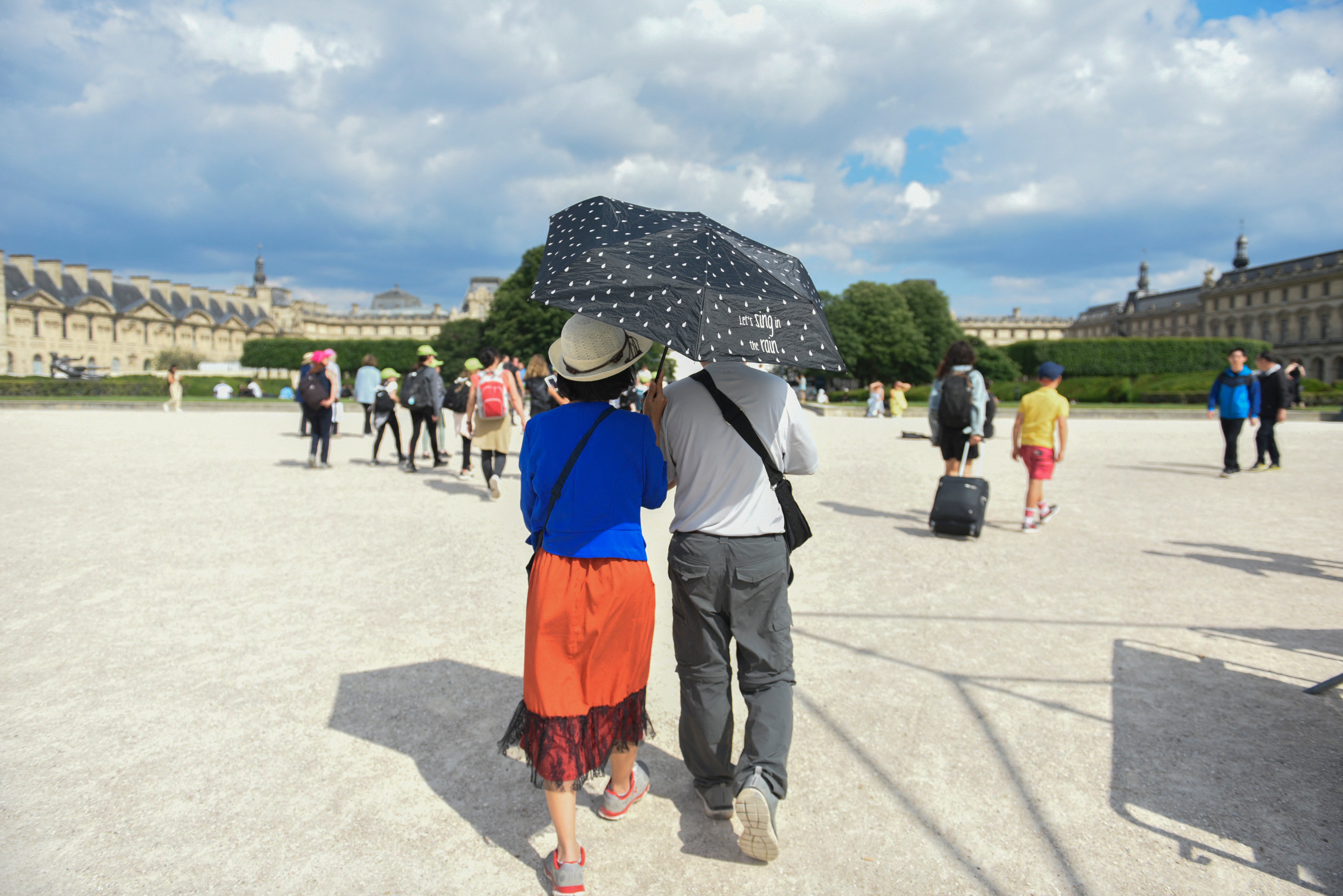 A couple hold an umbrella to protect themselves from the heat, in Paris, on in June