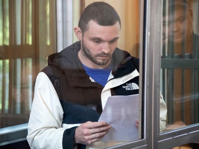 <p>Gordon Black stands in a glass cage in a courtroom in Vladivostok, Russia, on 19 June 2024</p>