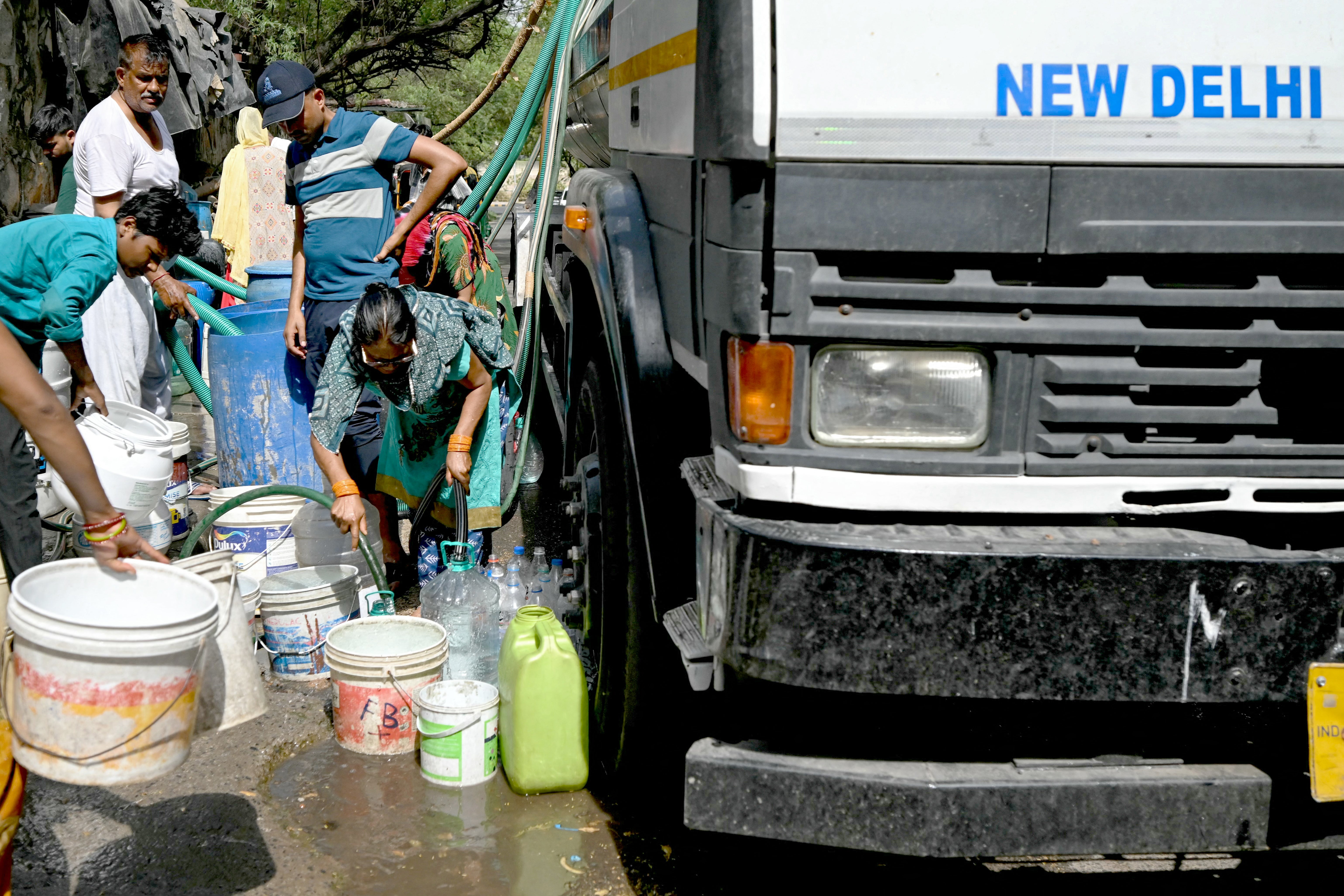 People fill their containers with water distributed by a municipal tanker in Delhi
