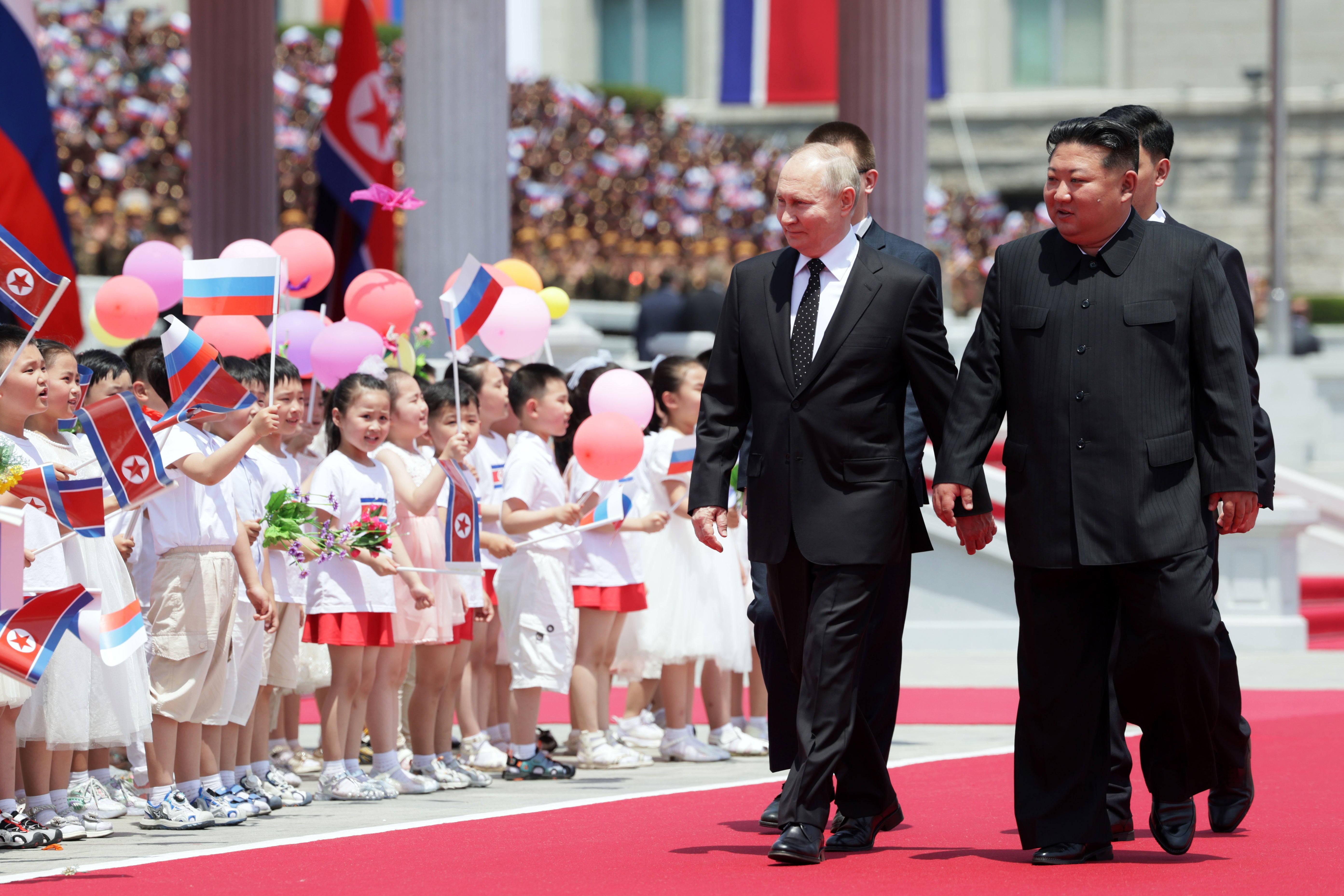 Russian President Vladimir Putin (L) and North Korean leader Kim Jong Un (R) attend an official welcoming ceremony during their meeting in Pyongyang