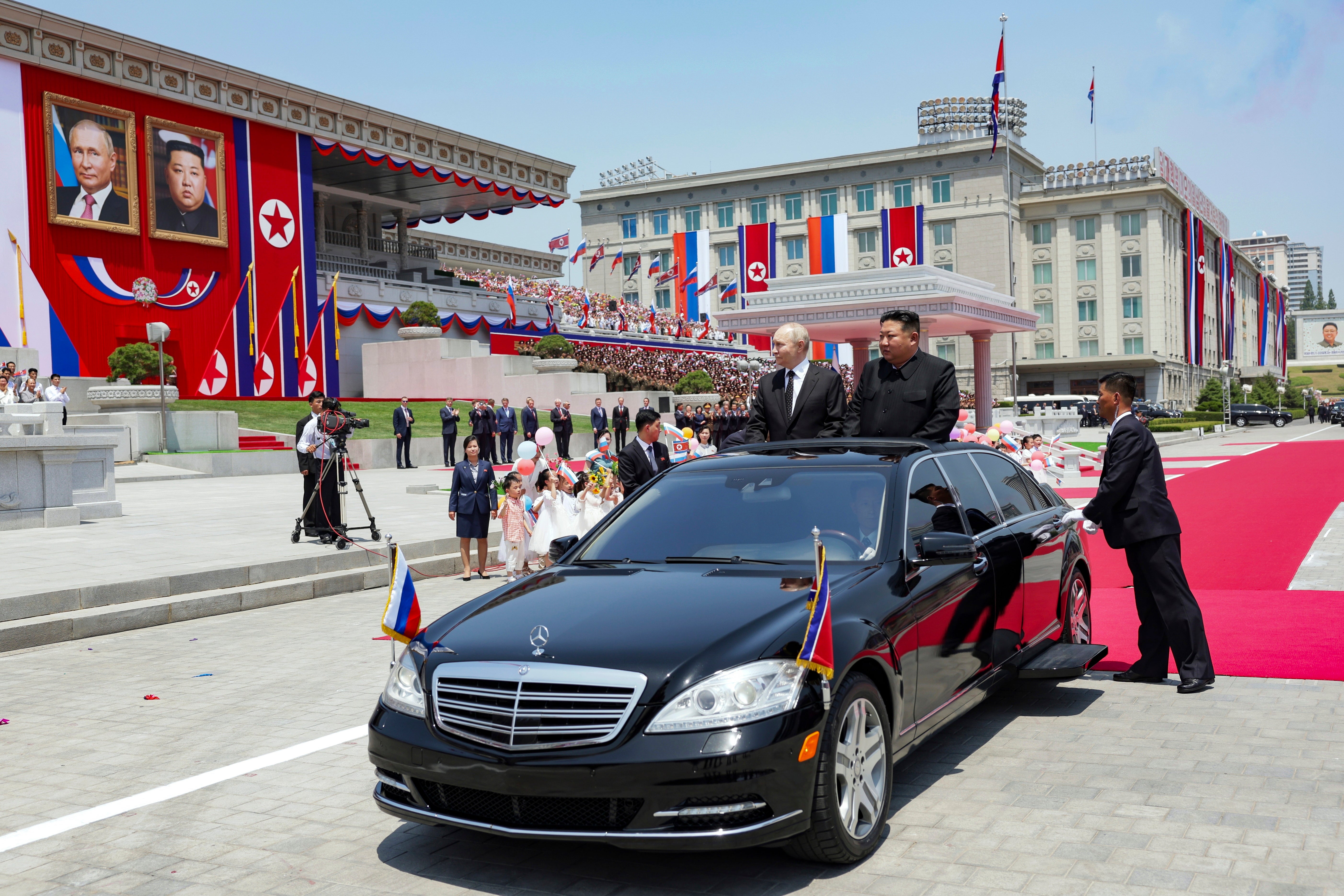 Russian President Vladimir Putin, left, and North Korea's leader Kim Jong Un, right, arrive to attend the official welcome ceremony in the Kim Il Sung Square in Pyongyang