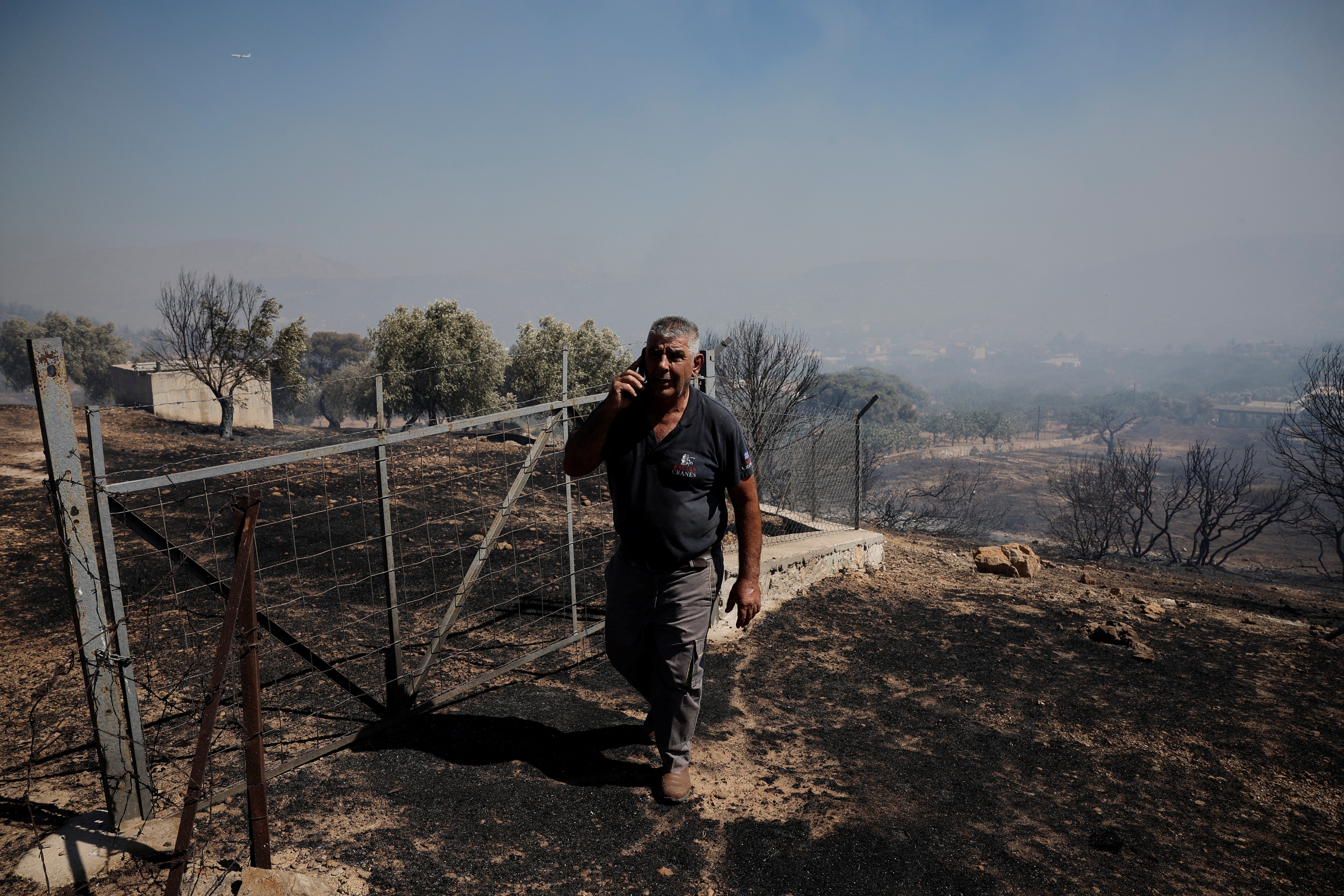 A man walks in an area burned during a wildfire, in Kitsi, near the town of Koropi, Greece, June 19, 2024