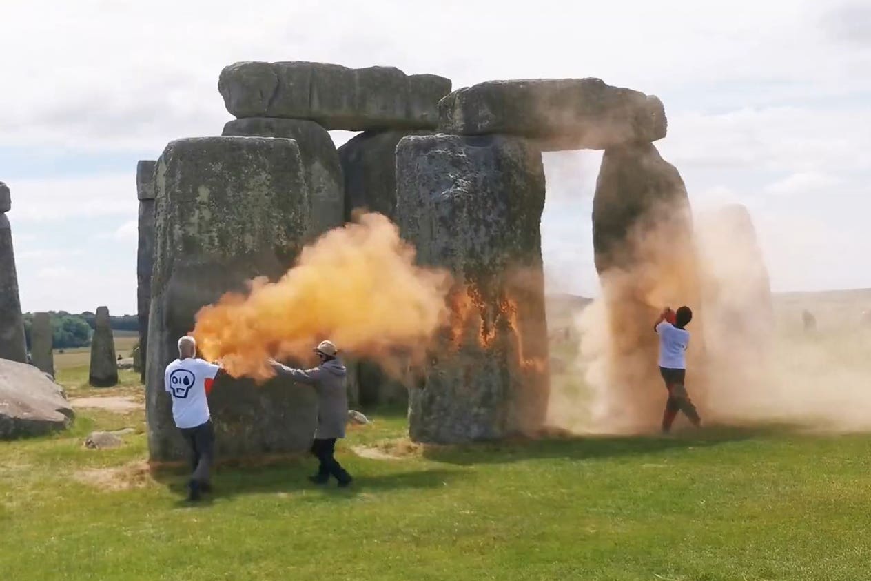 Screen grab taken from handout video of Just Stop Oil protesters spraying an orange substance on Stonehenge