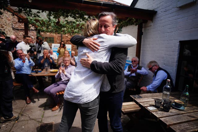 Foreign Secretary Lord David Cameron greets parliamentary candidate for Wells and Mendip Hills, Meg Powell-Chandler, during a visit to the Lamb Inn in Axbridge, Somerset (Ben Birchall/PA)