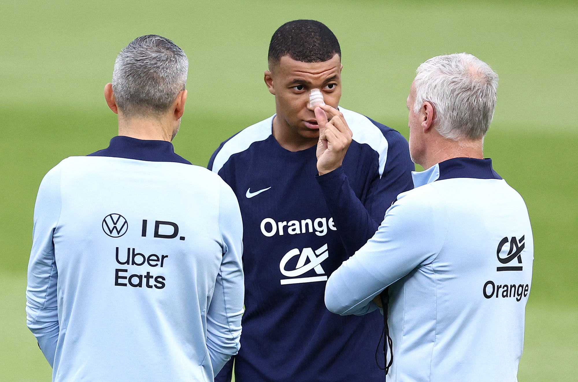 Kylian Mbappe speaks with manager Didier Deschamps in training