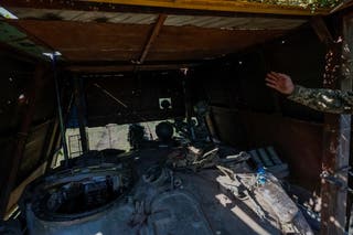 The Ukrainian soldier shows off the roof of the tank, protected by a cage fixed with wooden planks to protect against drones