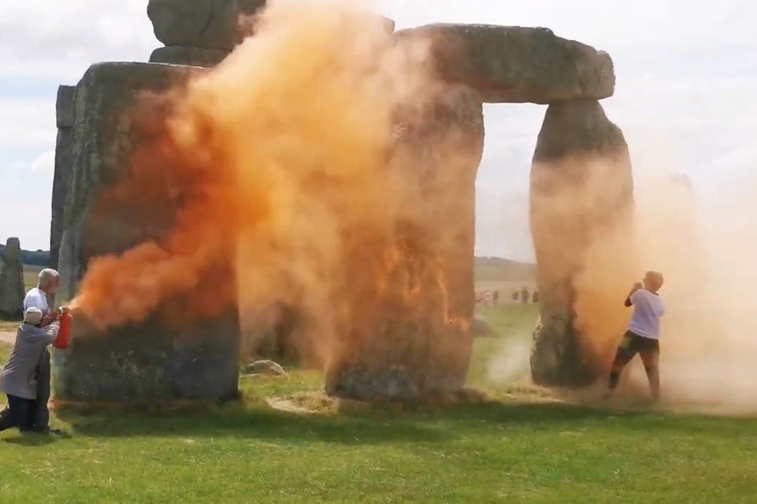 Just Stop Oil protesters spraying an orange substance on Stonehenge (Just Stop Oil/PA)