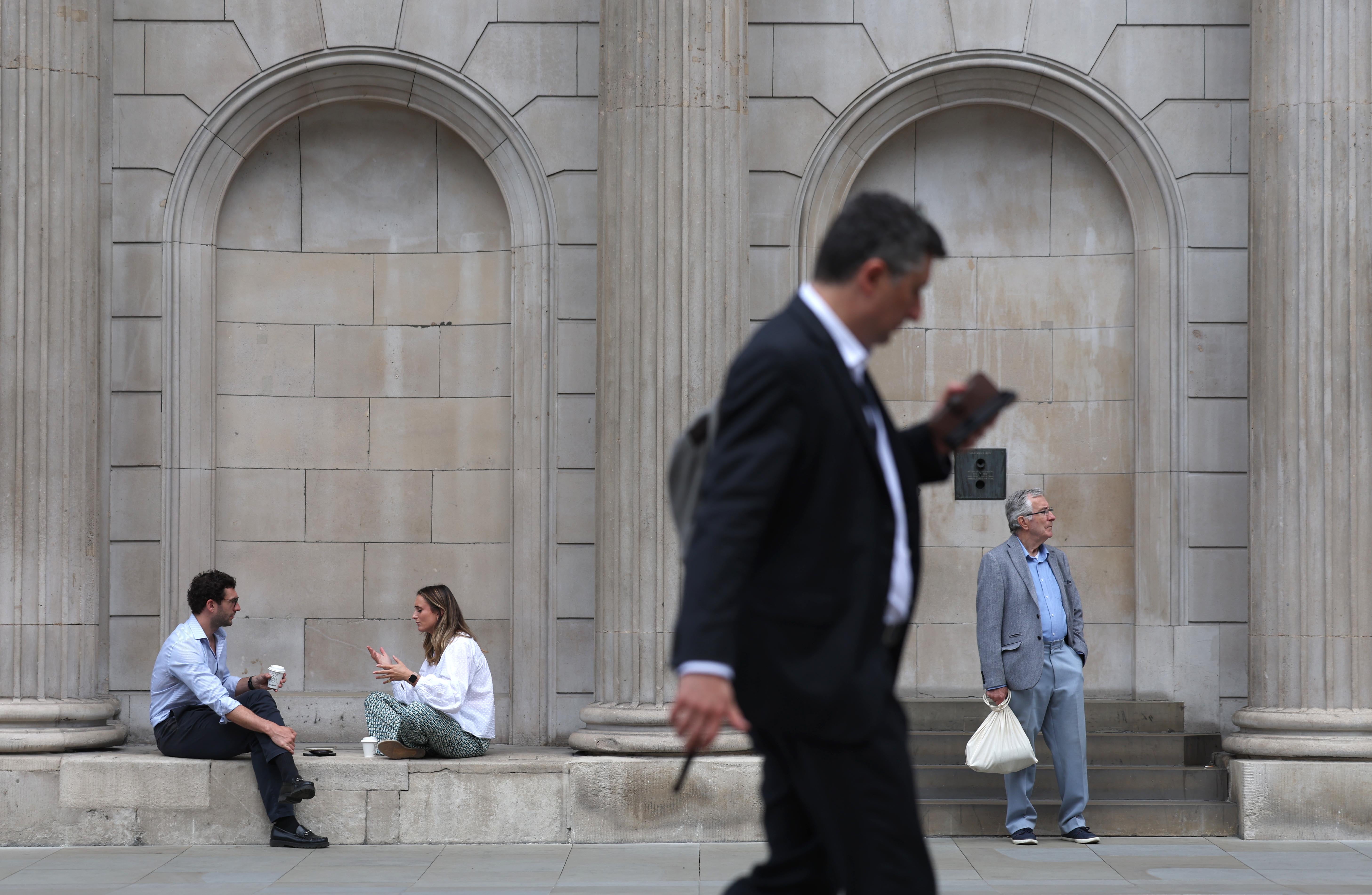 People walk past the Bank of England in the City of London financial district