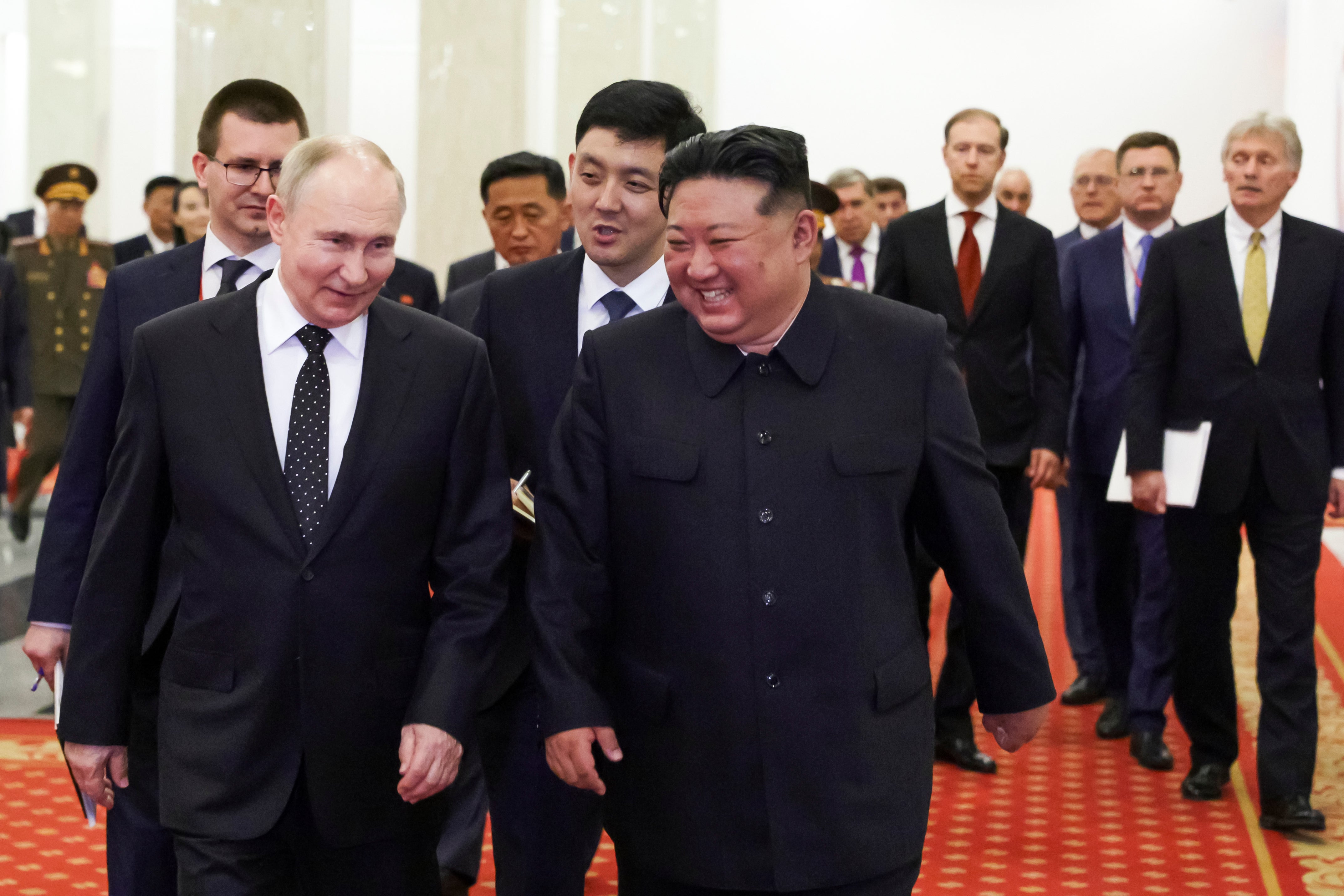 Putin and Kim Jong-un talk to each other as they walk after a signing ceremony in Pyongyang, North Korea
