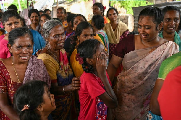 Family members weep near the dead bodies of victims who died after consuming toxic illegal alcohol in Kallakurichi district of India’s Tamil Nadu state on 20 June 2024