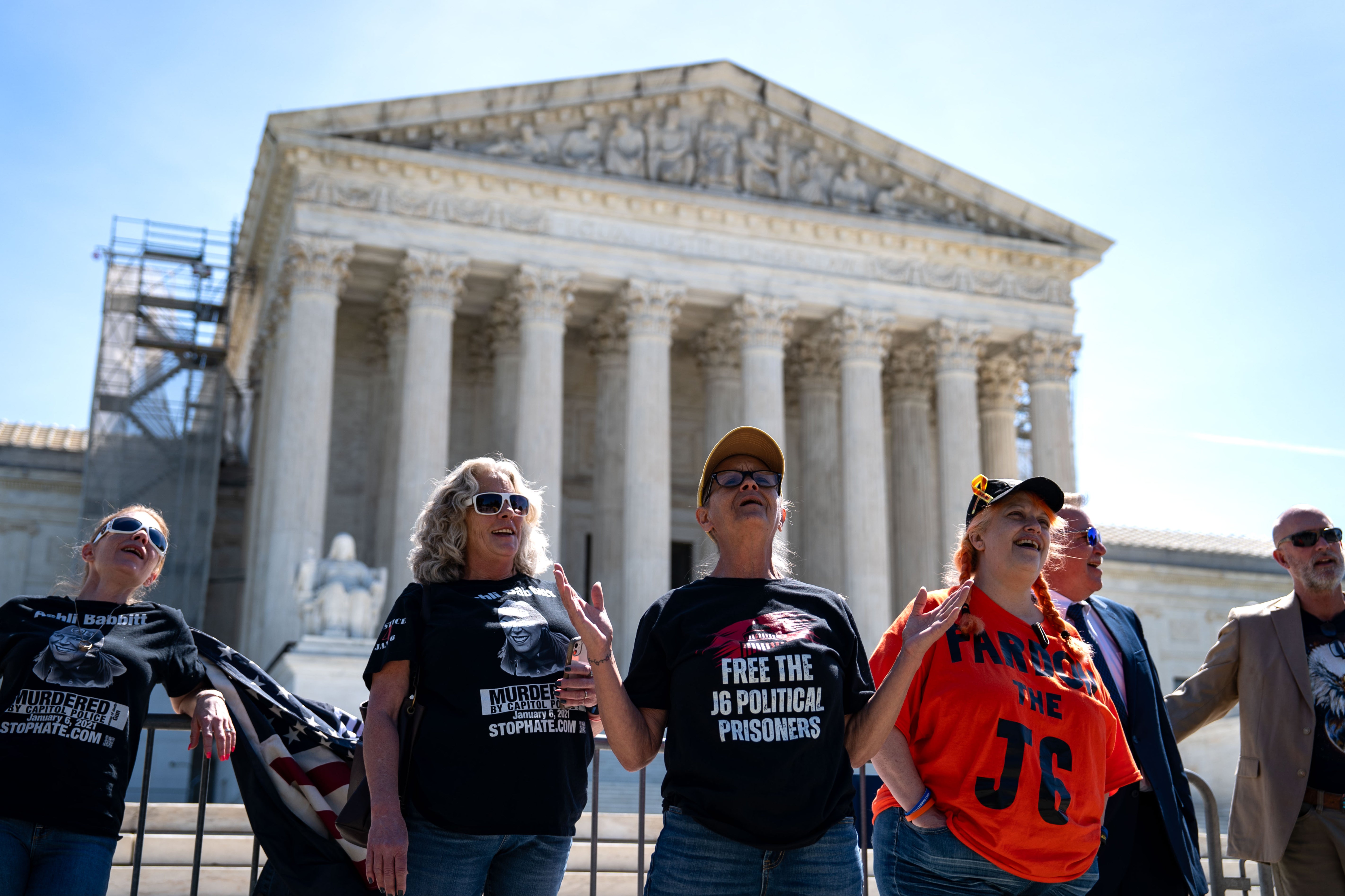 Supporters of January 6 defendants including Micki Witthoeft, the mother of Ashli Babbitt, sing “God Boss the USA” outside of the Supreme Court on April 16. Now, the court has put some of the Jan. 6 riot convictions in question