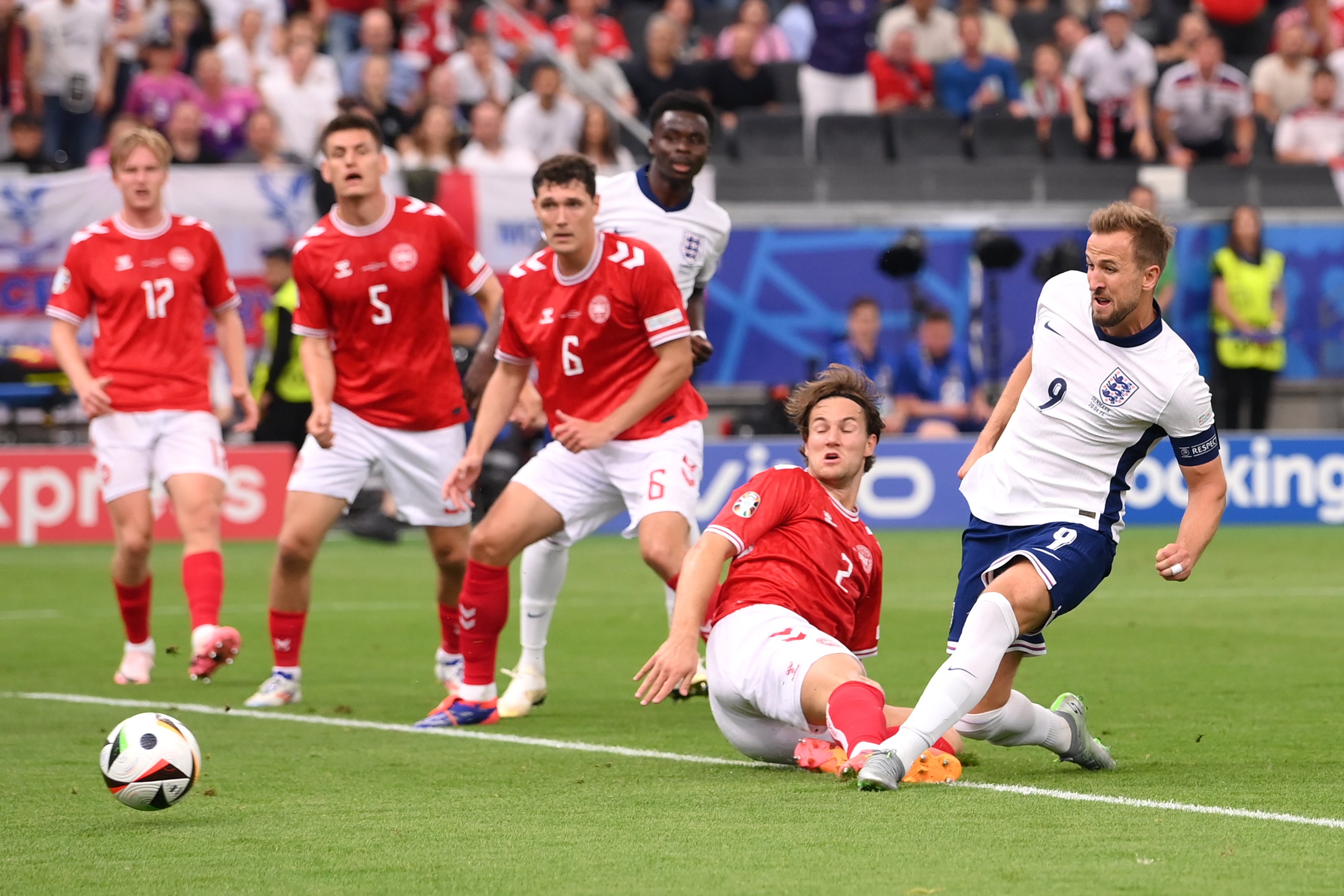 Kane slides the ball into the corner of Denmark’s goal
