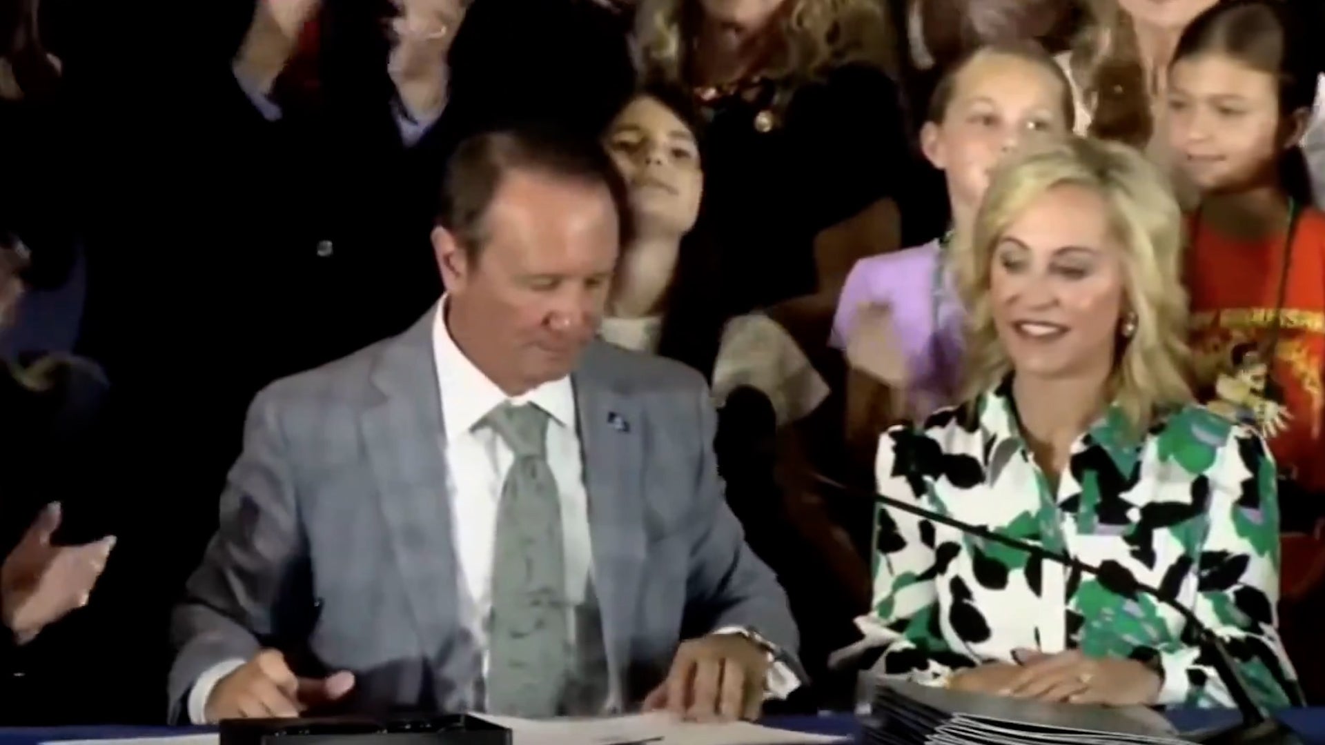 A student appears to faint as Louisiana Governor Jeff Landry signs legislation on June 19 that forces public schools to hand the Ten Commandments in every classroom