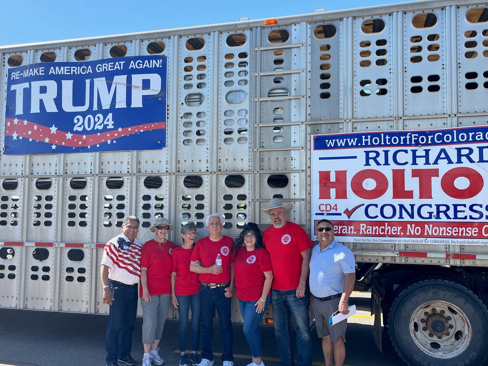 Richard Holtorf, second from right, poses with supporters next to his campaign sign-emblazoned cattle truck