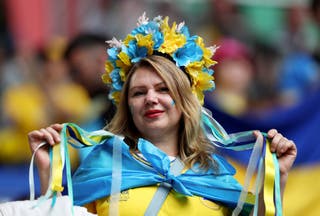 Ukrainian fans wearing floral headbands and Ukrainian flags pose for a photograph before the UEFA EURO 2024 group stage match between Slovakia and Ukraine in Dusseldorf.