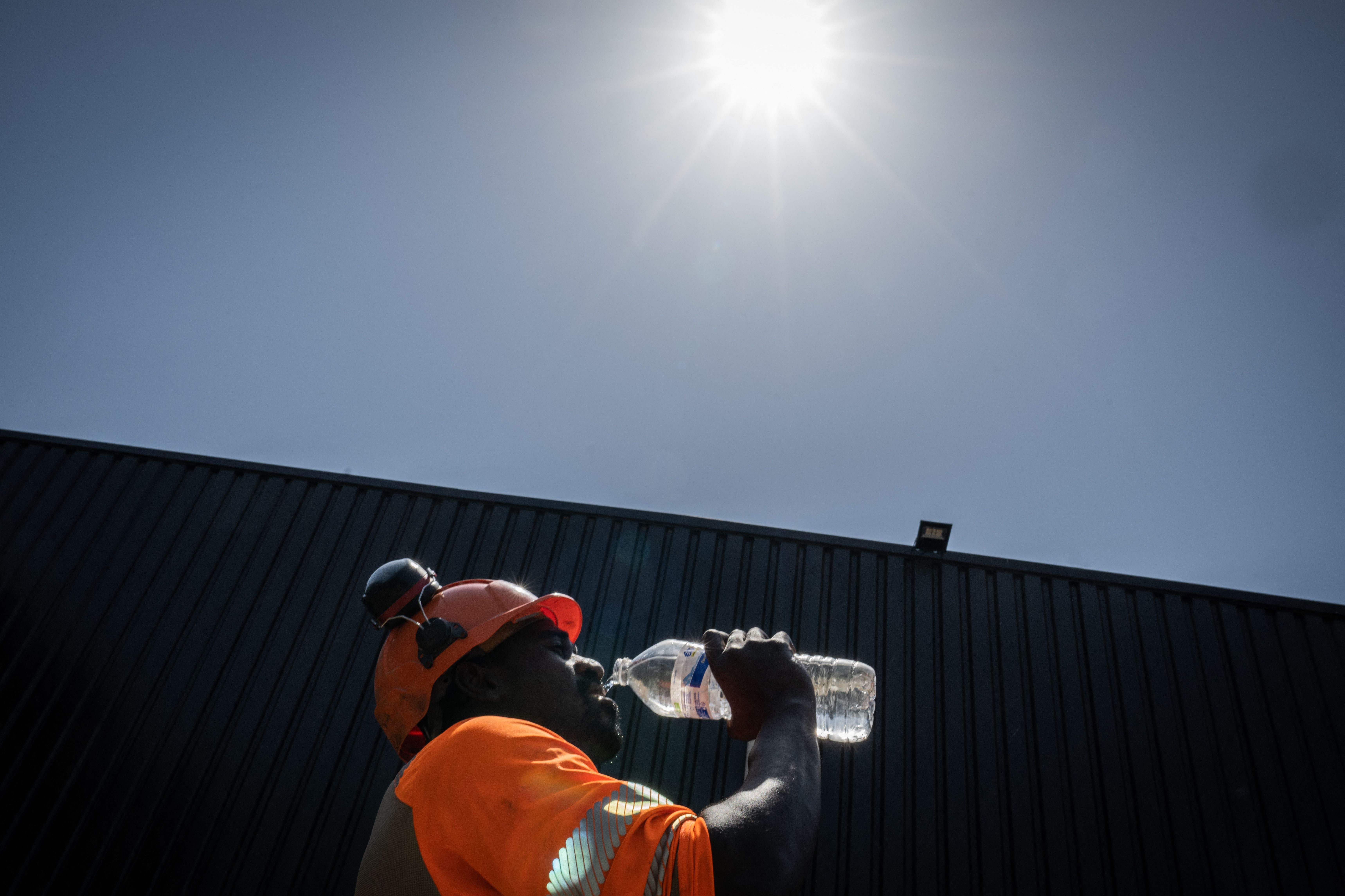 A construction worker pictured drinking water on a hot, sunny day. There are many groups that are more vulnerable to heat-related illness, including patients who take SSRIs or pregnant people