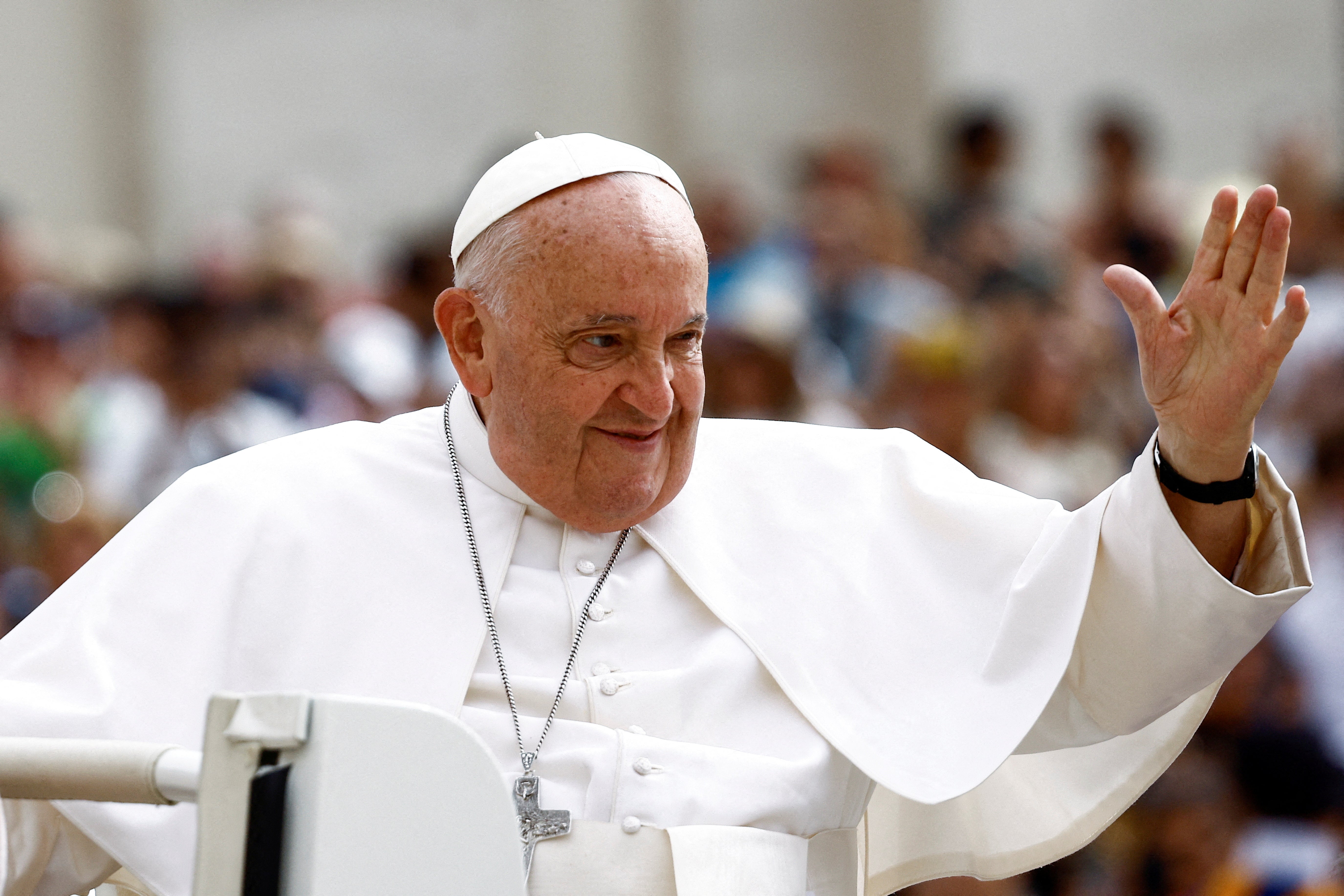 Pope Francis greets people as he arrives for the weekly general audience at Saint Peter's Square at the Vatican