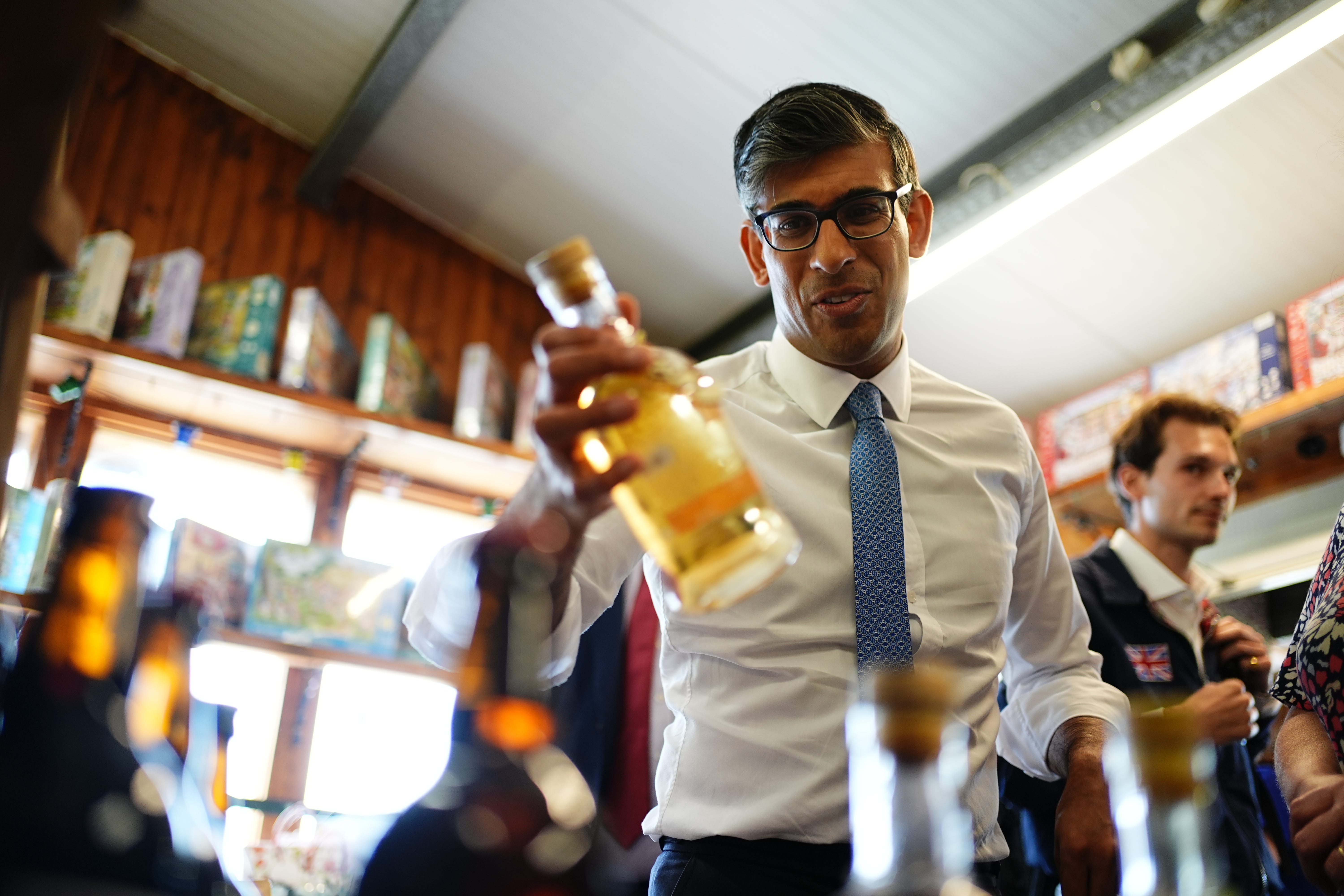 Prime Minister Rishi Sunak holding a glass bottle during a visit to a farm shop in Wales (Aaron Chown/PA)