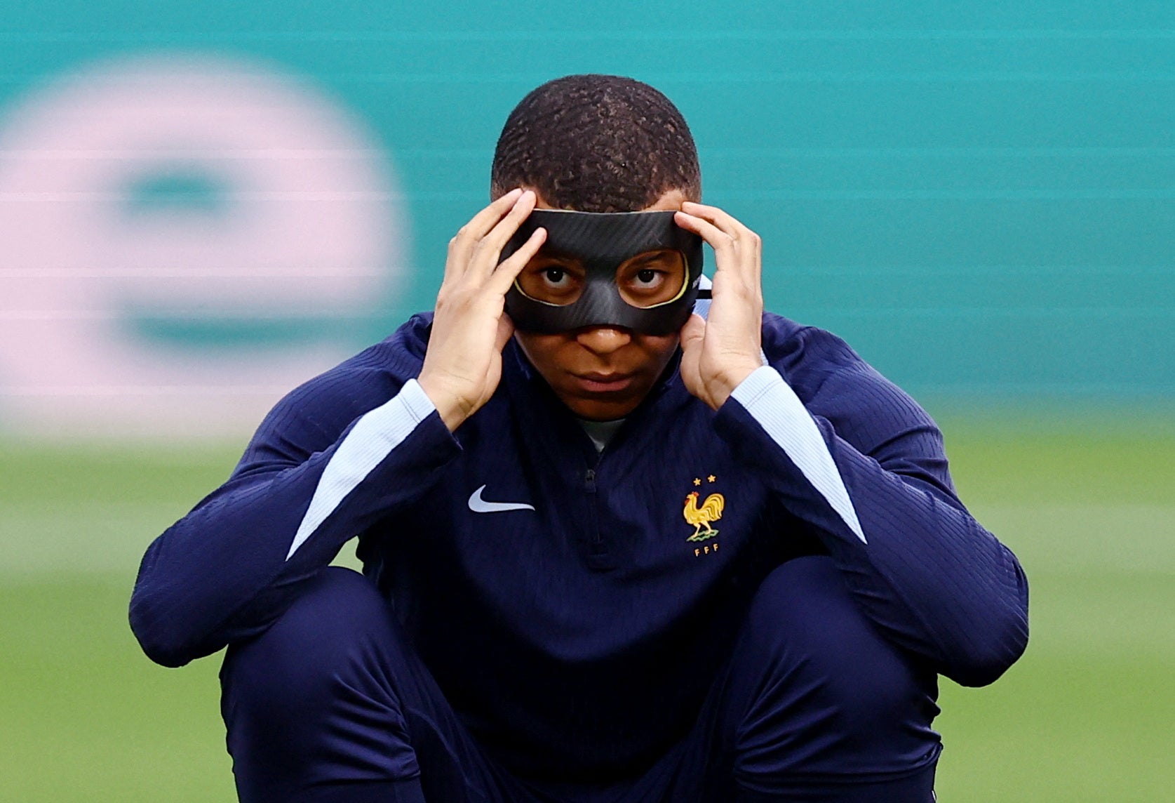 Kylian Mbappe wears a black face mask during his warm-up against the Netherlands