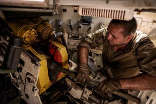 A serviceman of the 24th Mechanized Brigade named after King Danylo of the Ukrainian Armed Forces, loads a shell inside a 2S1 Gvozdika self-propelled howitze