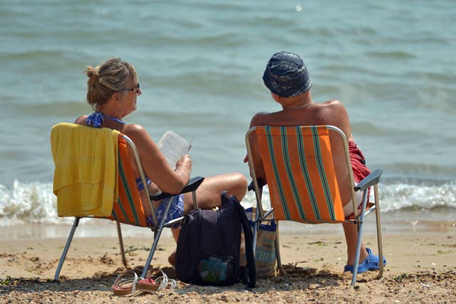 <p>A couple enjoy the hot weather on the beach at Clacton-on-Sea in Essex</p>
