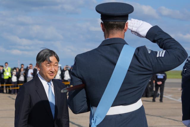 <p>Emperor Naruhito is saluted by a member of the honour guard as he and Empress Masako arrive at Stansted Airport, England</p>