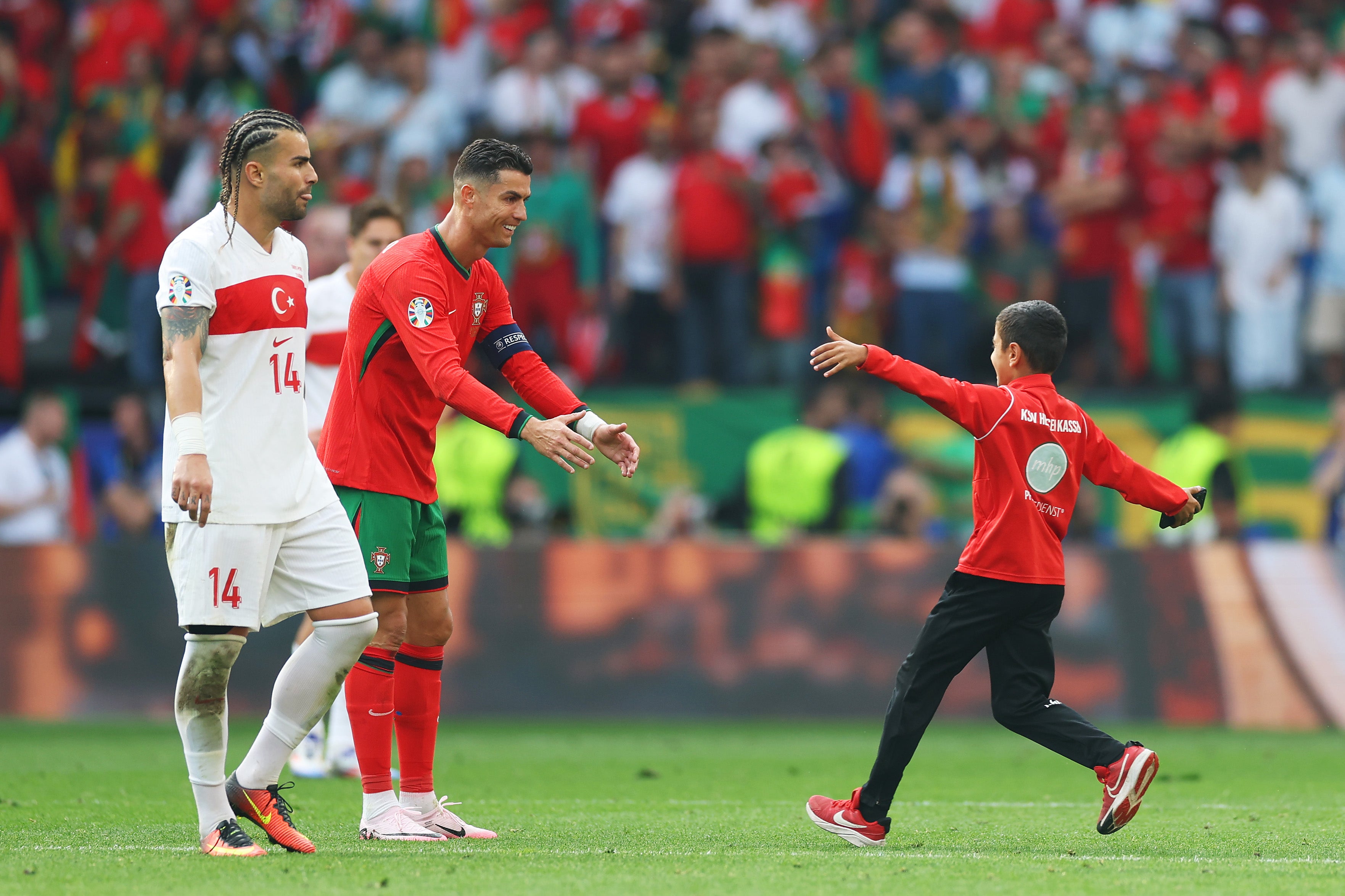 Cristiano Ronaldo reaches out to hug a young pitch invader