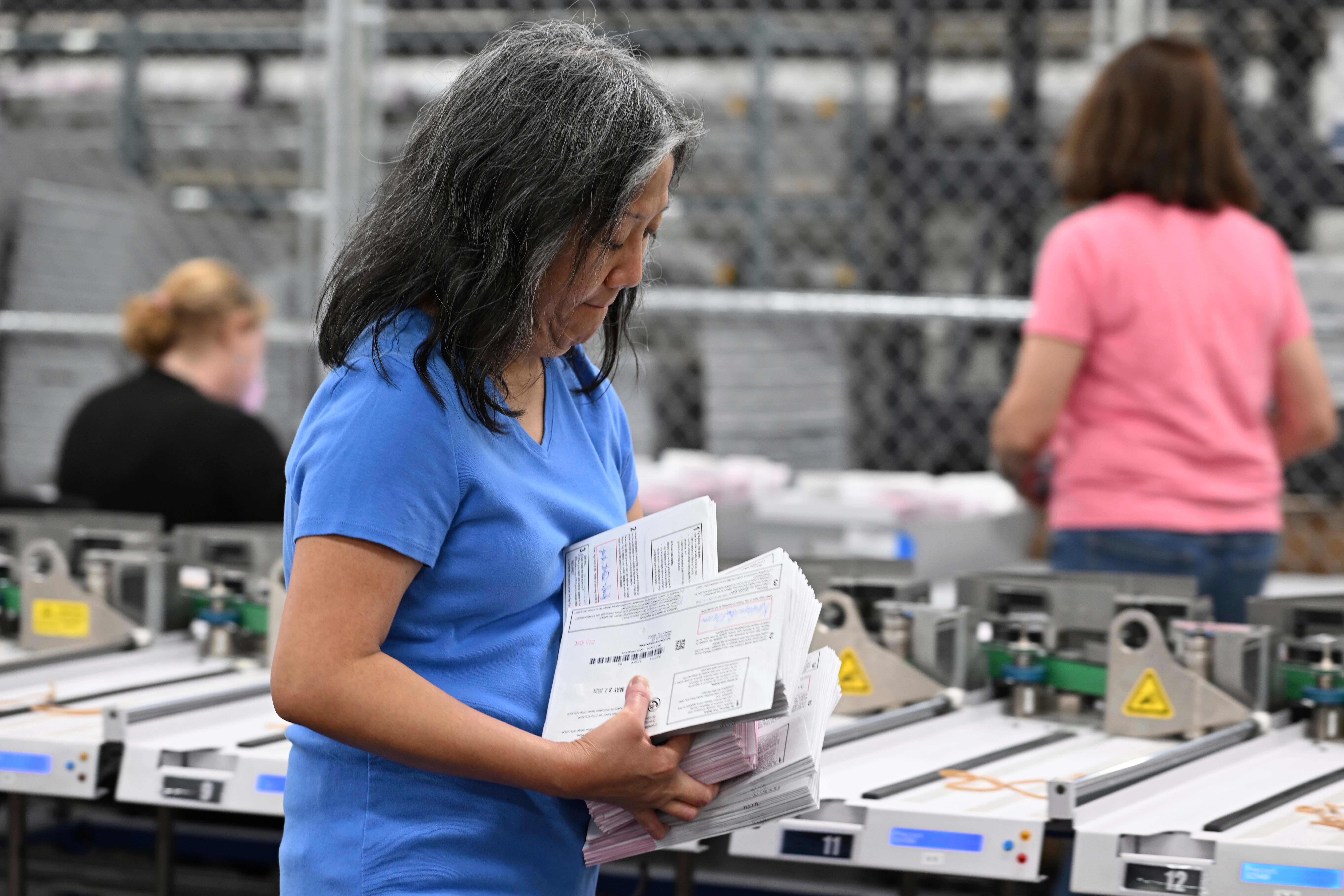 A Washoe County election worker carries stacks of ballots inside a ballot processing room in Reno, Nevada. The state is one of several that Donald Trump’s campaign and Republican Party officials are suing to reject early voting ballots