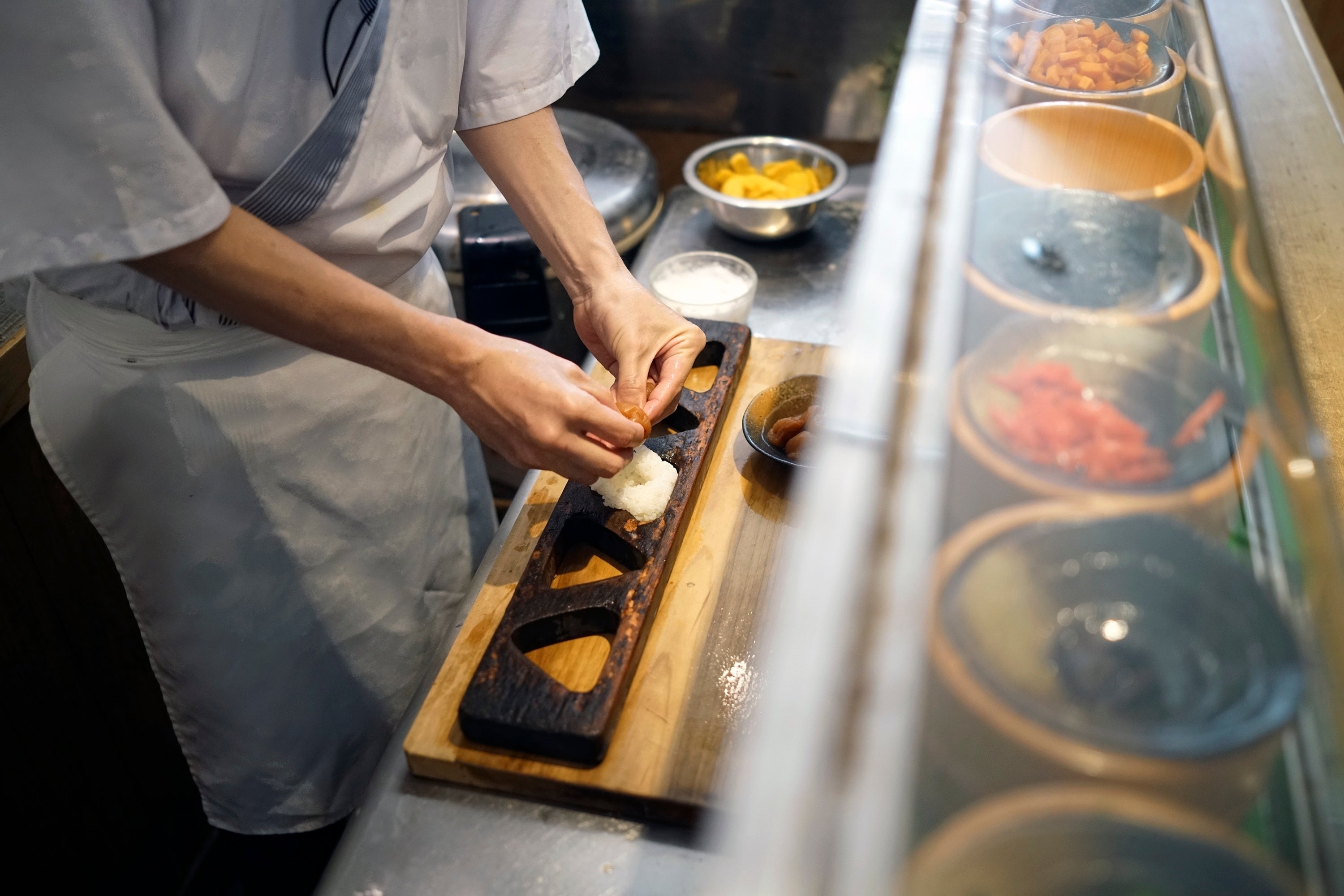 Yosuke Miura makes a rice ball with pieces of grilled salmon at Onigiri Asakusa Yadoroku, Tokyo’s oldest onigiri restaurant