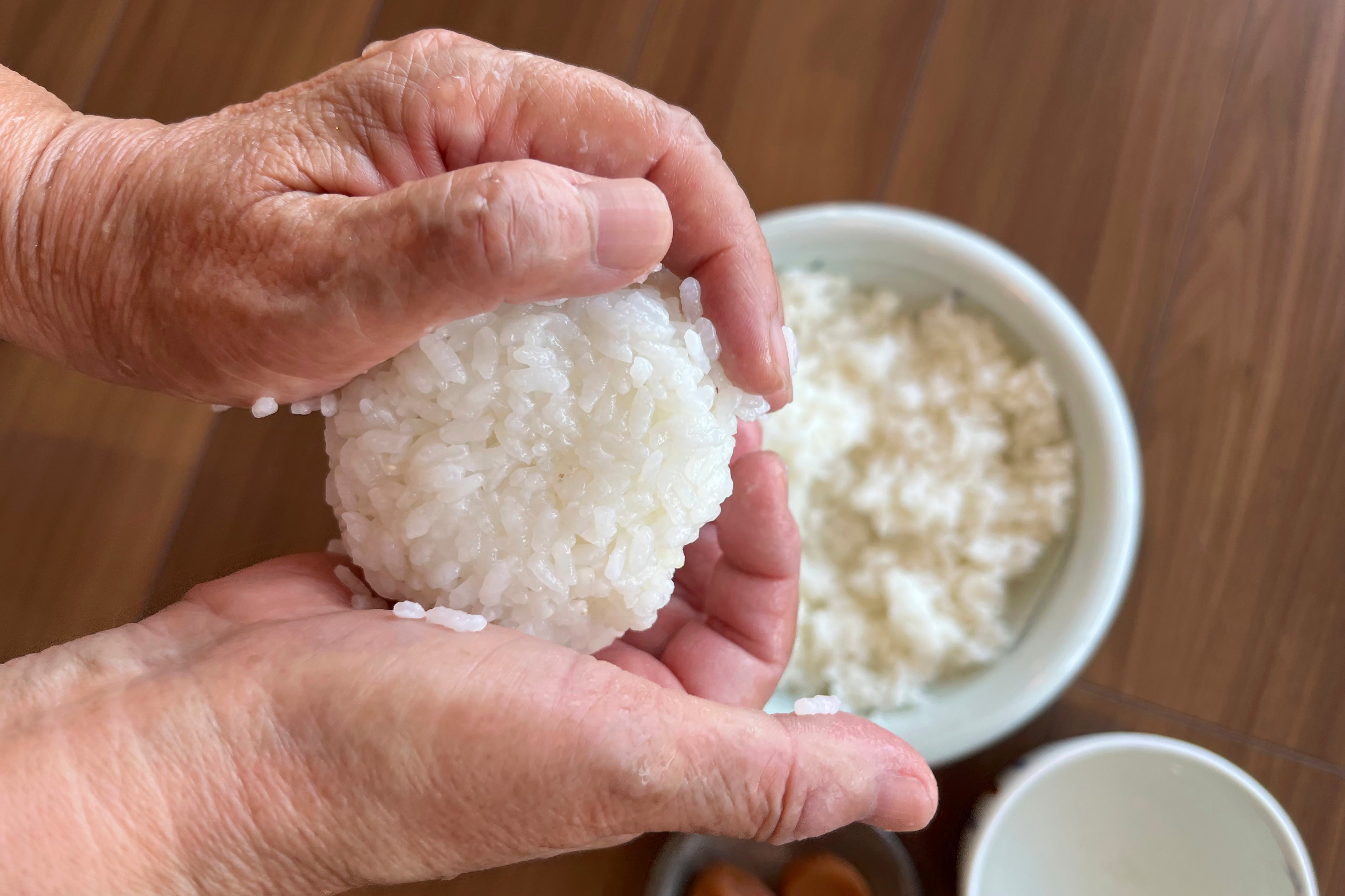 A rice ball is made in Tokyo, on June 14, 2024. (AP Photo/Yuri Kageyama)