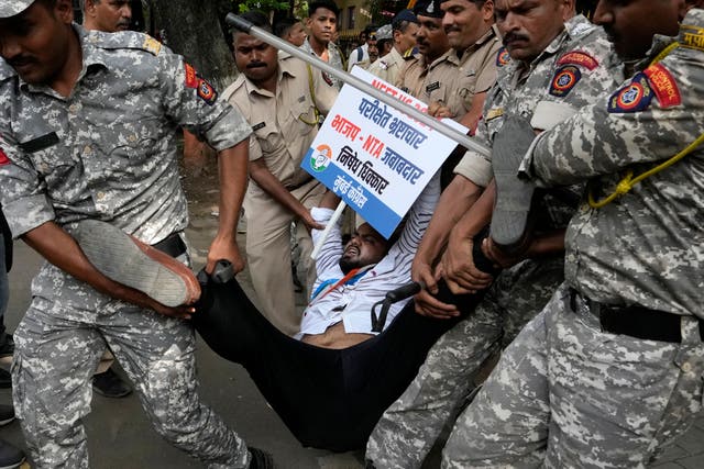 <p>Police detain a worker of the opposition Congress party worker during a demonstration against alleged irregularities in NEET exam, in Mumbai </p>