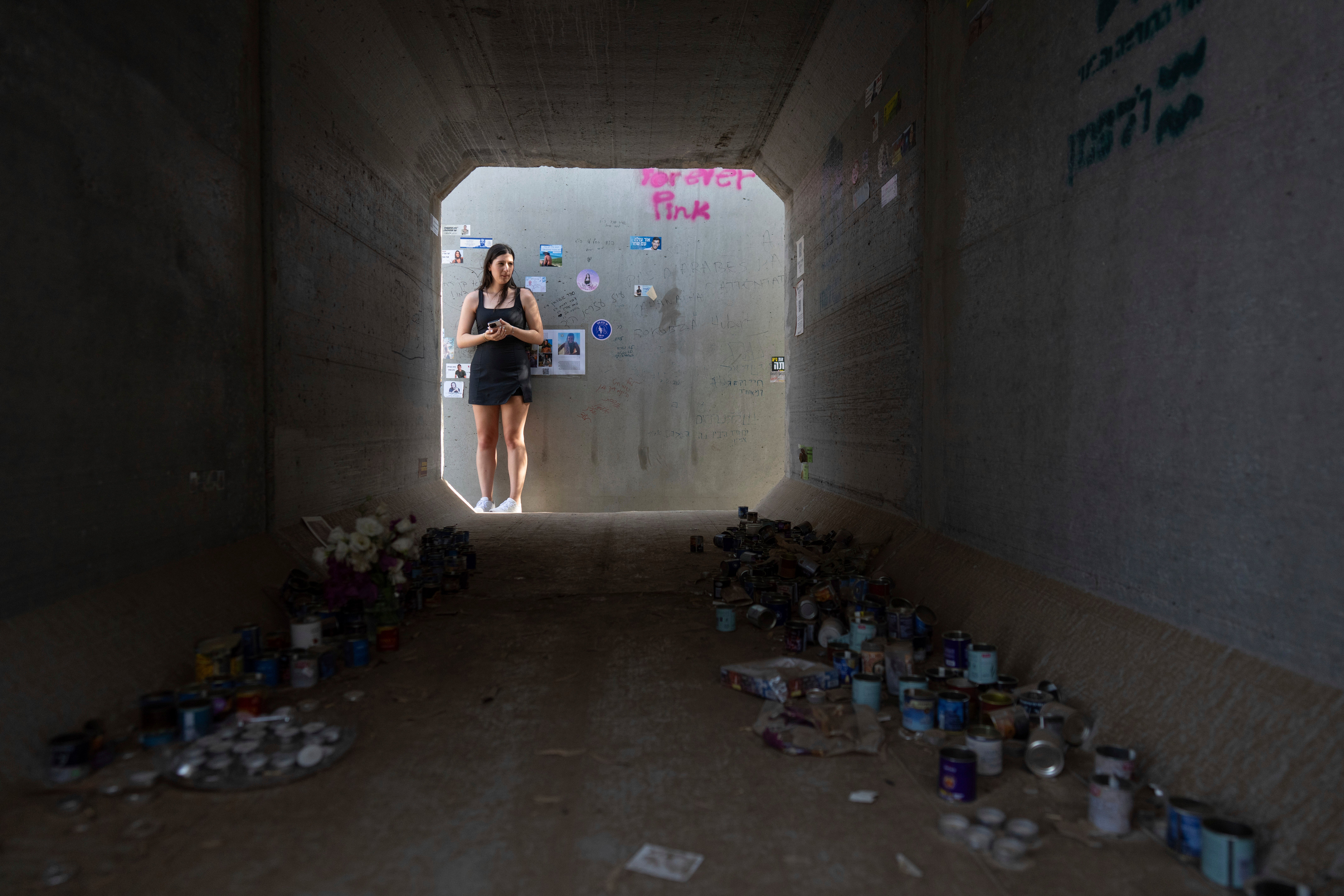 A woman stands next to a shelter at the site of the Tribe of Nova music festival, where at least 364 people were killed and abducted during the Hamas attack