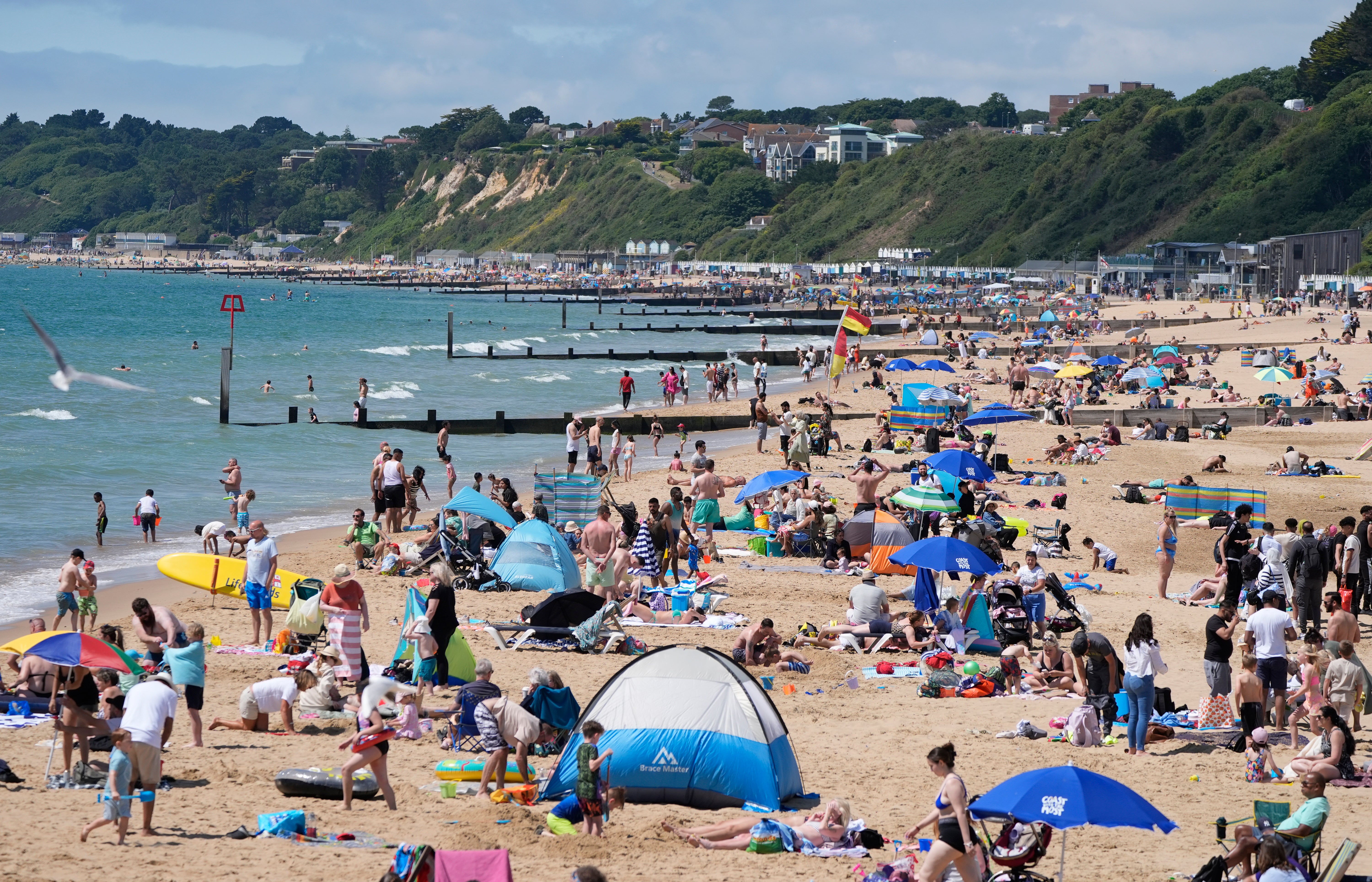 People enjoying the sunny weather on Bournemouth Beach in Dorset