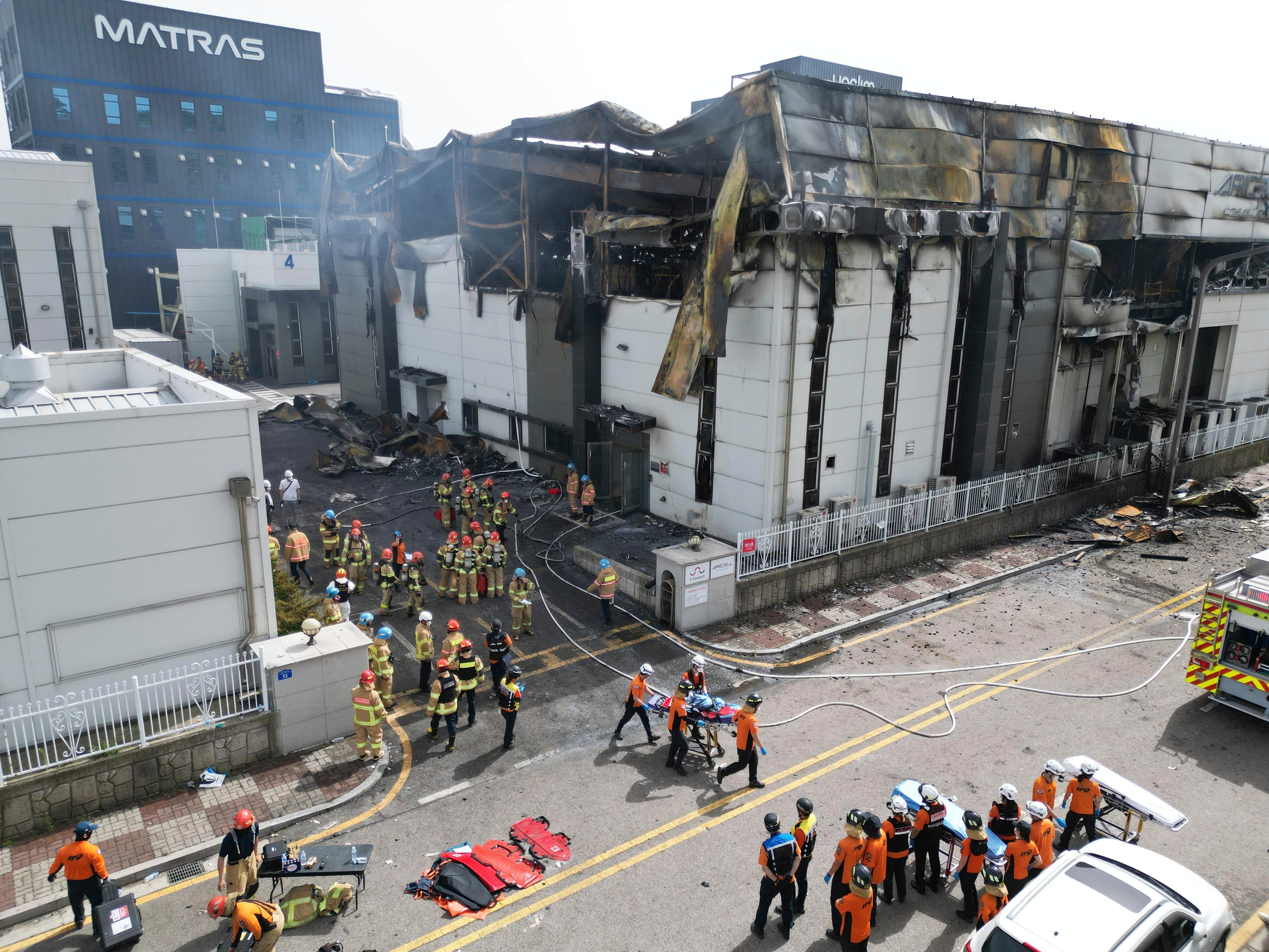 Firefighters carry a body at the site of a fire at a lithium battery manufacturing factory in Hwaseong, South Korea