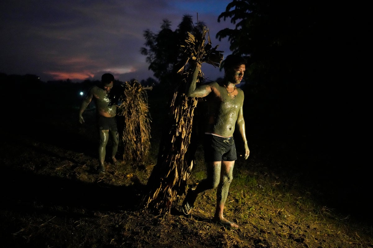 AP PHOTOS: Philippine villagers smear mud on their bodies to show devotion to St. John the Baptist