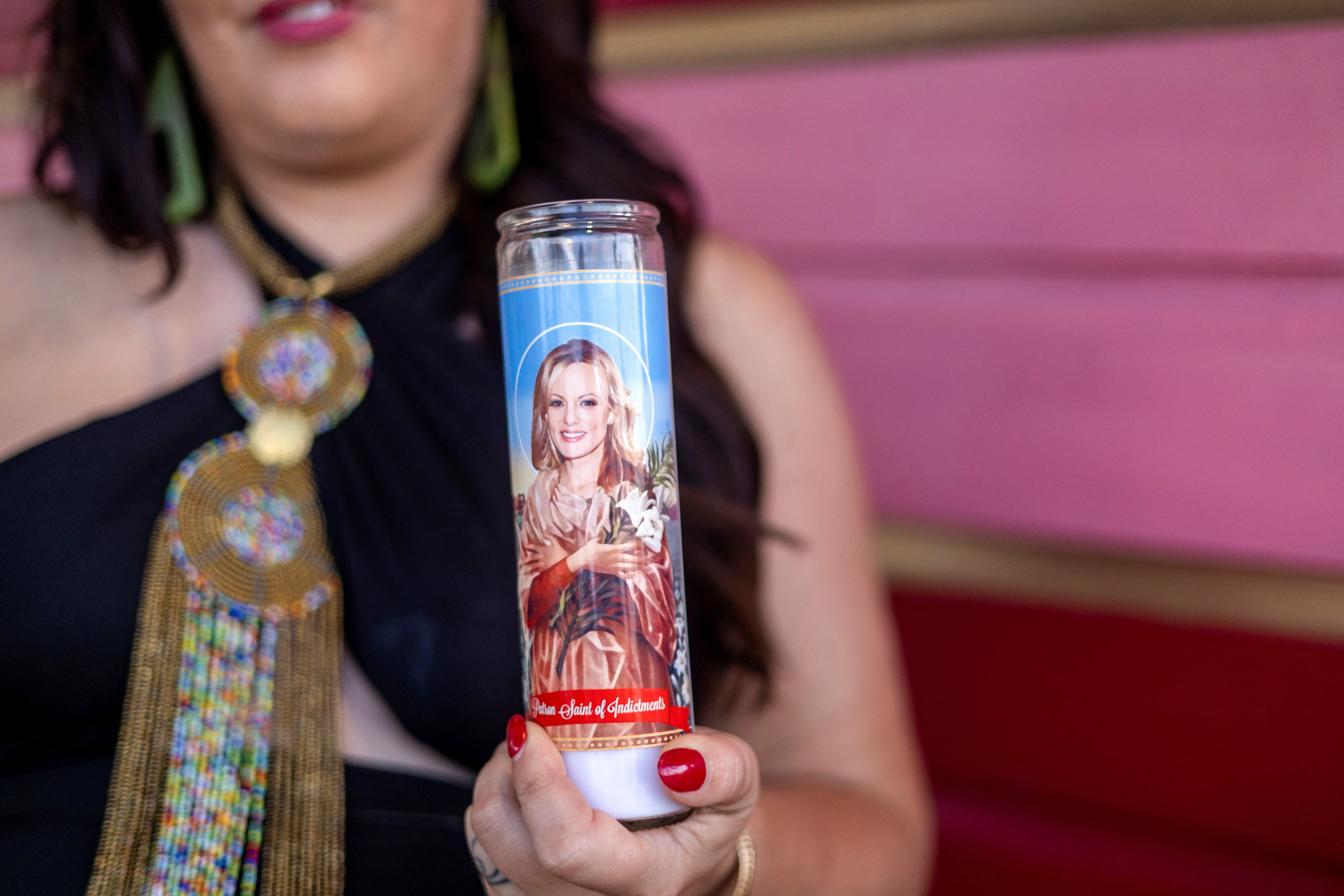 Steaphine Kauffman holds a candle depicting Stormy Daniels as the ‘Patron Saint of Indictments’ outside her comedy show in New Orleans